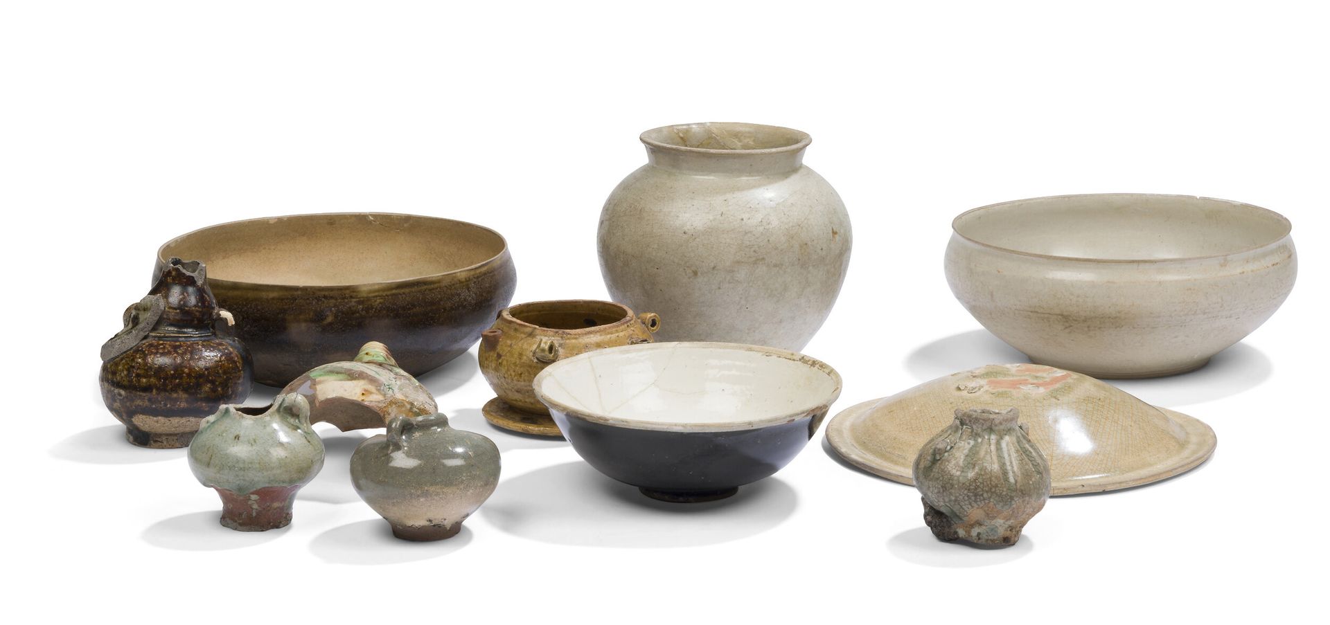 Onze céramiques, Asie du Sud-Est, Sawankhalok, Vietnam, Chine, XIIe-XVIe siècles
- Quatre petites jarres à anses à couverte céladon et brune ; - une jarre ovoïde et une coupe à base plate toutes les deux à couverte crème et bord évasé ; - une coupe en grès à couverte brune et beige à fond plat non émaillé ; - un fragment en grès à couverte brune, verte et ocre à décor d'une fleur et d'un motif décoratif moulé ; - un bol à couverte noire à l'extérieur et crème à l'intérieur ; - un couvercle à couverte céladon craquelé ; - un petit pot sur piédouche à couverte ocre-verte muni de quatre petites anses et trois orifices tubulaires autour du bord extérieur.
H. de 6 à 13 cm ; diam. de 9,5 à 19,5 cm
On y joint des gouaches et des descriptifs de l'ancien collectionneur, Monsieur Francis Barillet.

Provenance : 
Ancienne collection Francis Barillet.