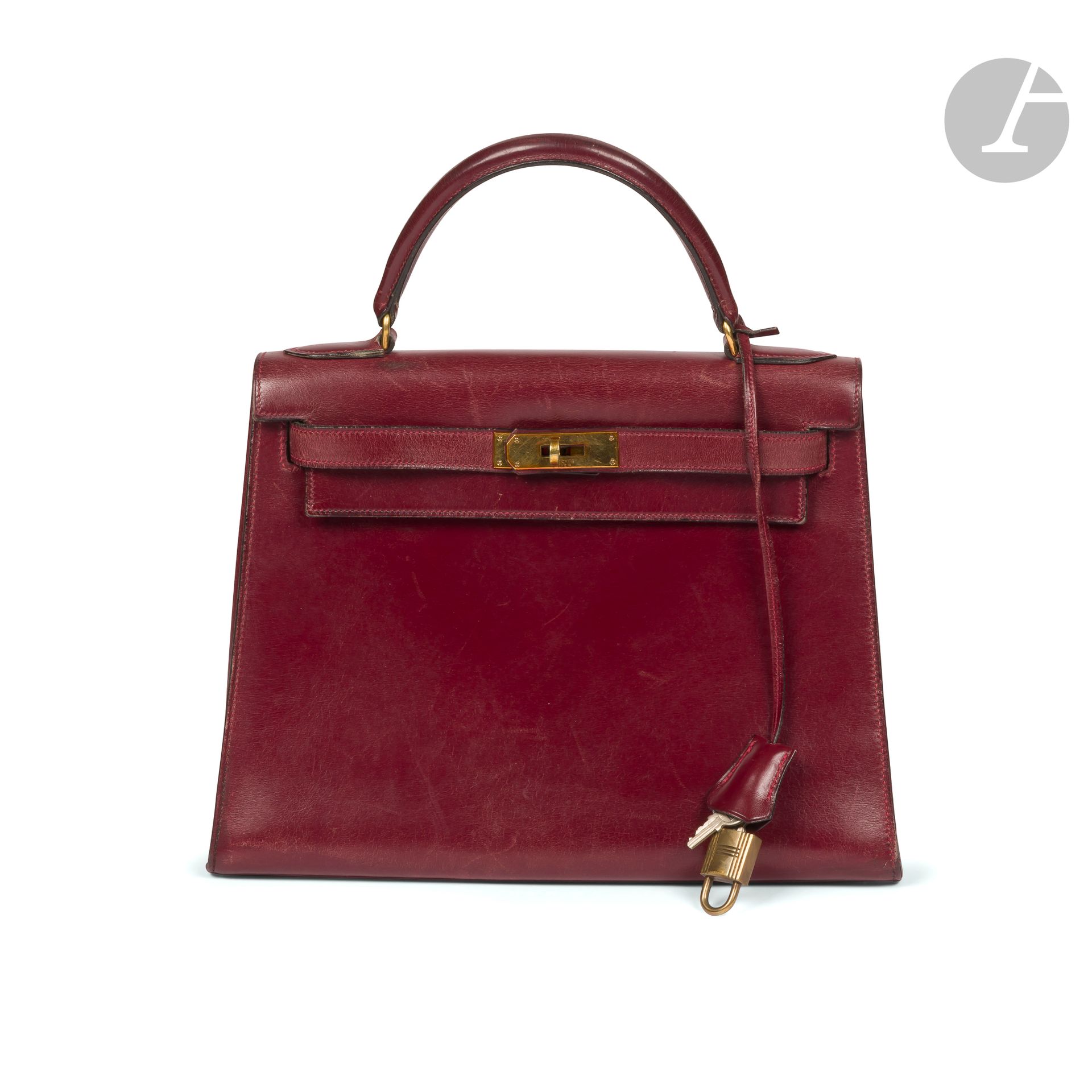 HERMÈS Paris
circa 1960
Kelly saddle bag 28 in burgundy box, gilded metal trim, padlock and two keys under clochette. 28.5 x 21.5 x 11.5 cm
(some wear to the corners, stains, a few scratches, scratches to the interior, slight play to the reel, oxidation to the jewelry)