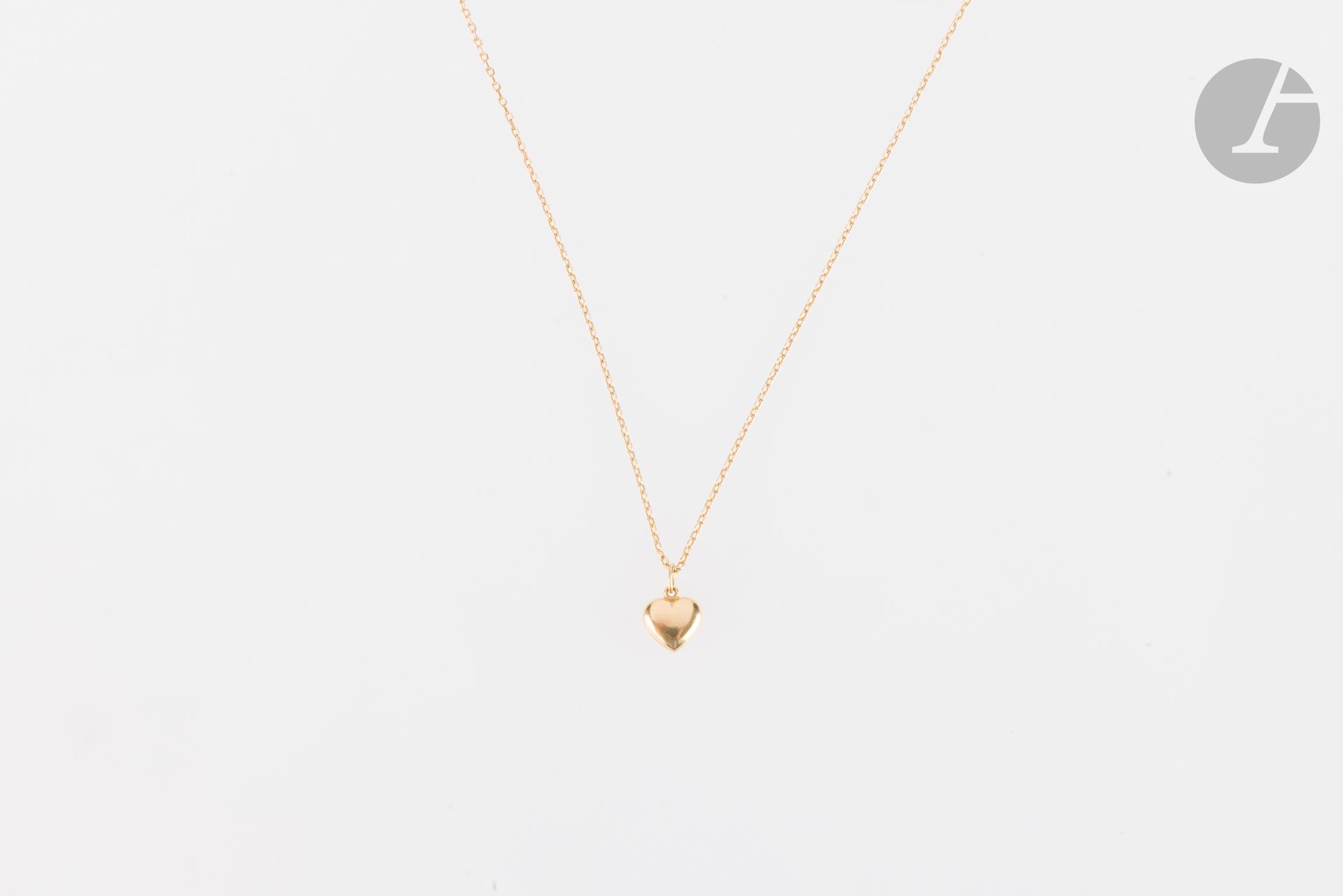 Chaîne en or 14K (585) retenant un pendentif en forme de coeur en or 18K (750). Longueur : 51 cm. Poids : 3,1 g