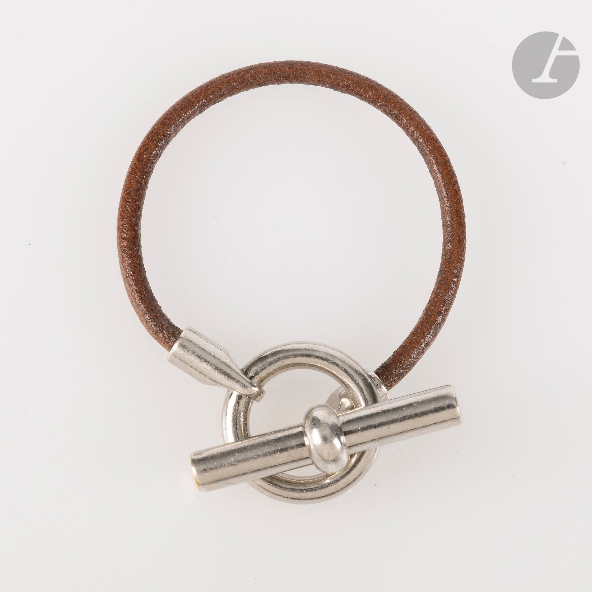 HERMÈS
GLéNAN bracelet in silver-plated metal and gold leather. Signed. L: 18 cm (marks and small traces of gilding on metal)