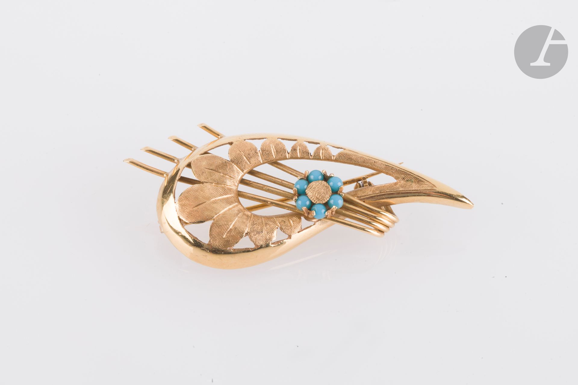 Broche en or 18K (750) à motif floral stylisé. Hauteur : 5 cm. Poids brut : 6,9 g (usures, chocs avec manques de matière)