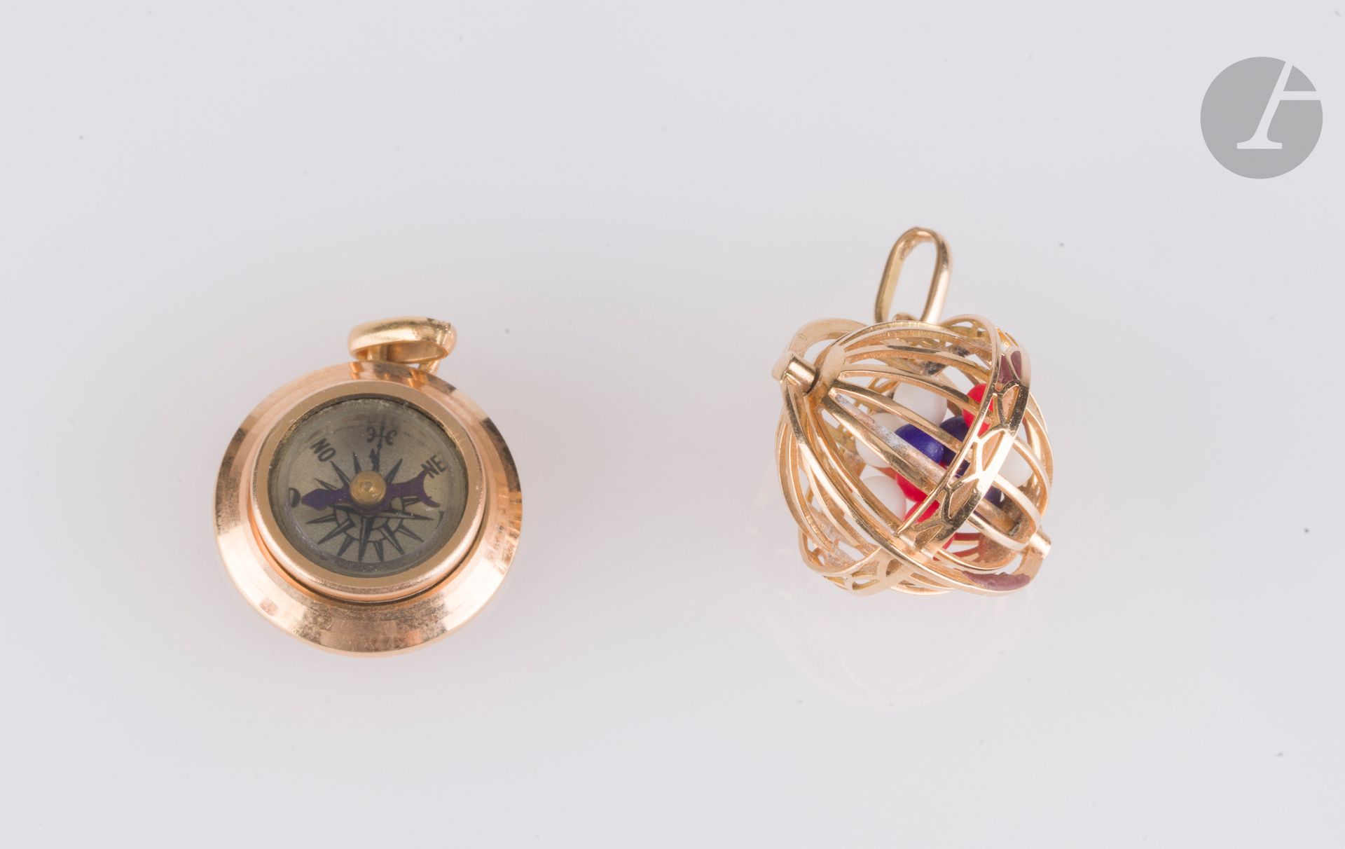 Lot de 2 pendentifs en or 18K (750), l'un en forme de boulier de loto et l'autre retenant une petite boussole. Poids brut : 7,4 g