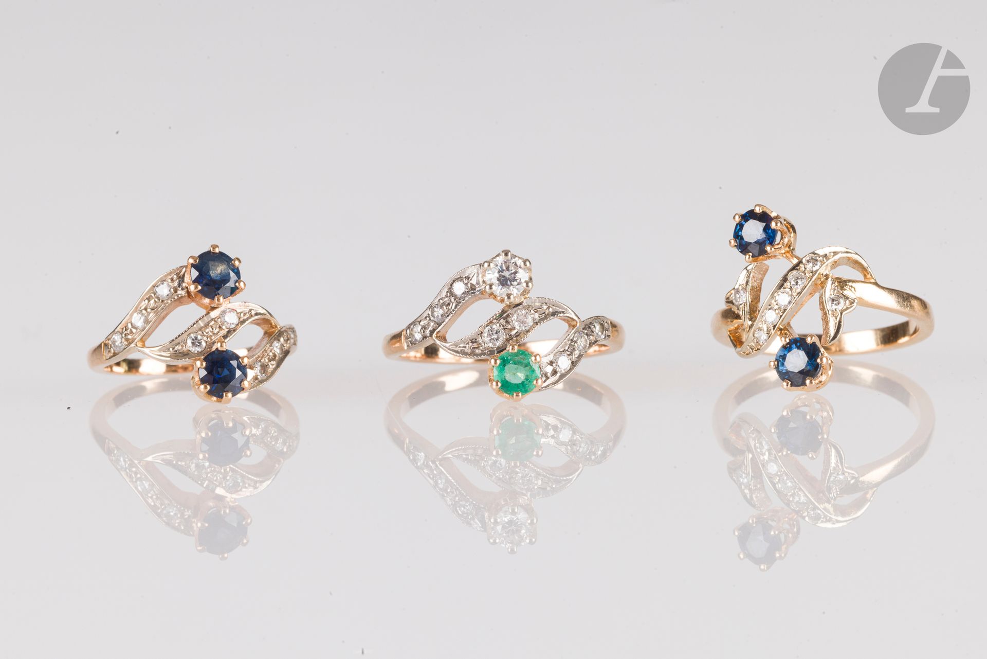 Lot de 3 bagues en or 18K (750), les deux premières croisées serties de saphirs et de diamants, la 3e agrémentée d'une émeraude et de diamants. Poids brut : 8,9 g