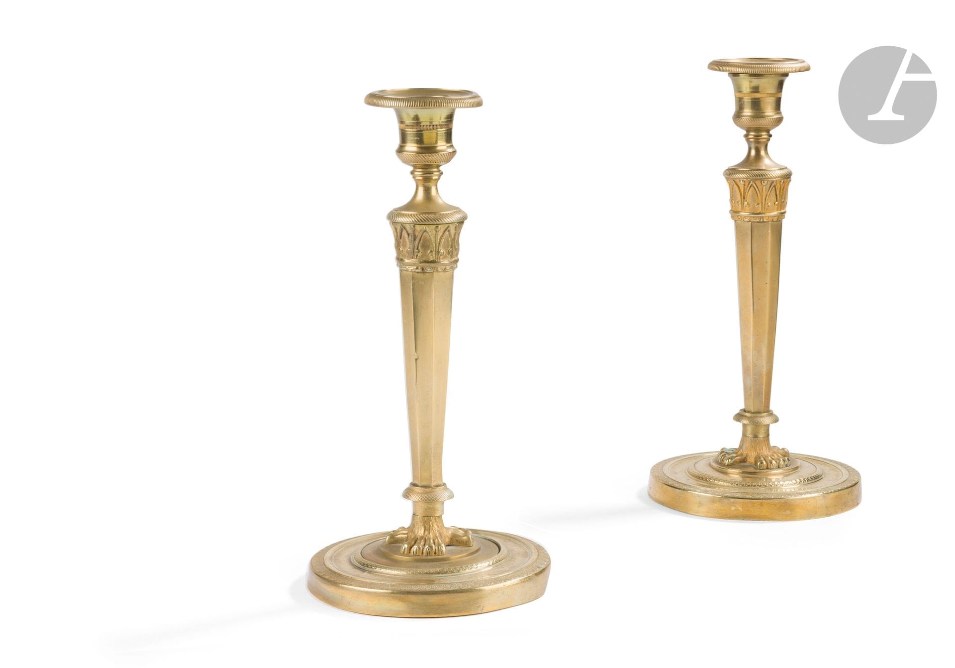 Pair of bronze torches (formerly gilded), the tapered shaft resting on a circular base with guilloché decoration; (accidents and restorations).
Empire period.
Height: 26cm