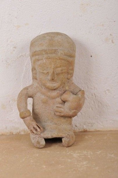Femme assise tenant un animal de son bras gauche. Terre cuite brune avec traces de peinture rouge et jaune. Culture Bahia, Équateur, 500 av. - 500 ap. J.-C. H : 14 cm - l : 8,5 cm - Ep : 6,5 cm État : bon.