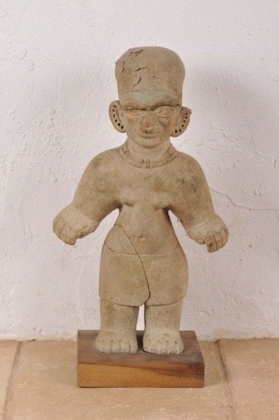 Femme debout parée d’un ornement nasale (Nariguera) et d’un collier. Terre cuite beige. Culture Tumaco, La Tolita, Équateur, 500 av. - 500 ap. J.-C. H : 33 cm - l : 19 cm - Ep : 13 cm État : manque au niveau de la jambe gauche (restauré). Fissures sur le visage et écaillures.