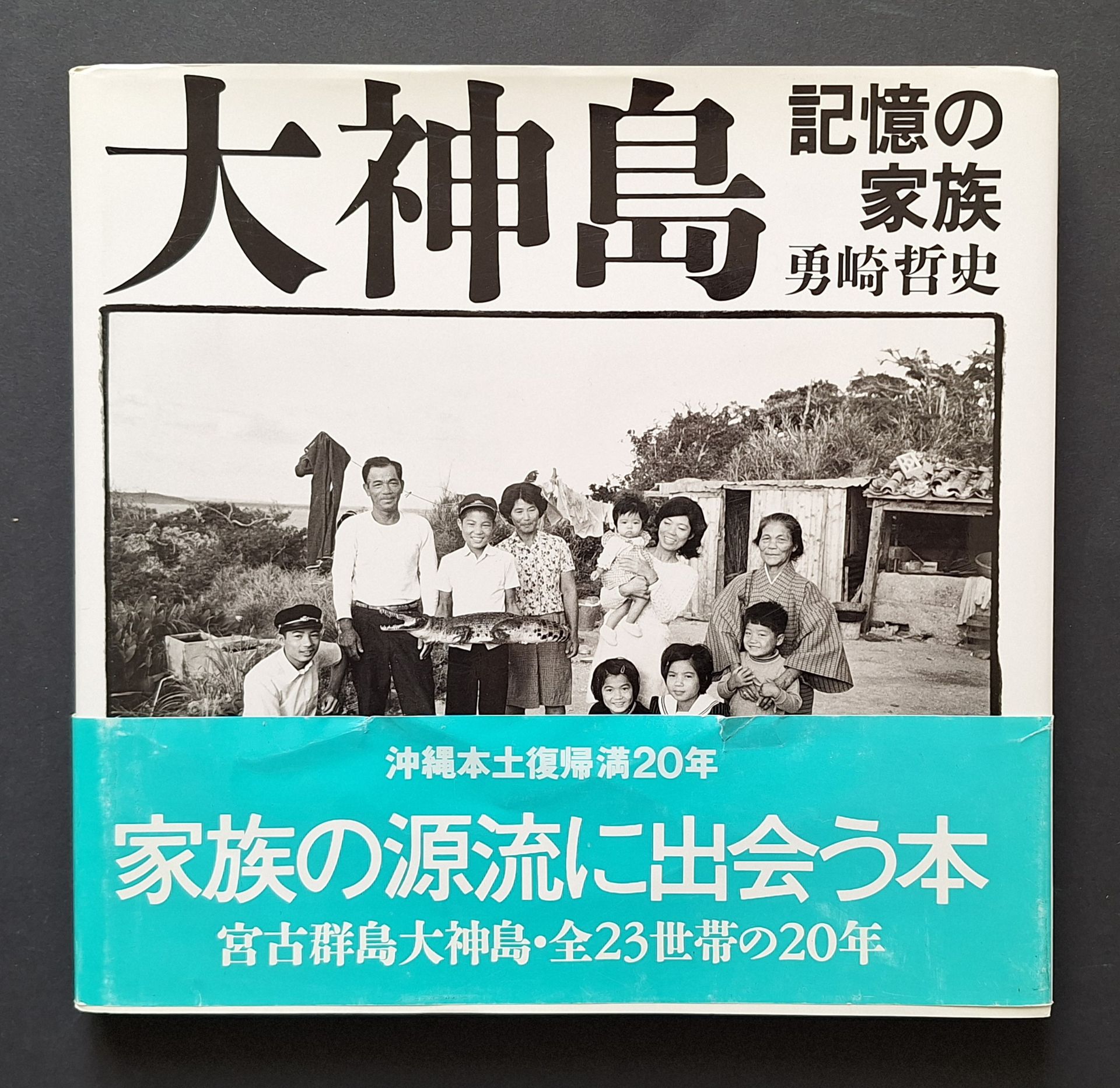 TETSUSHI, YUZAKI (1949)
Ohgami Island. Families Remembered.
Heibonsha, Tokyo, 1992.
In-4 (25 x 25 cm). Édition originale. 120 pp. Photographies et textes d'Yuzaki Tetsushi. Cartonnage blanc titré au dos sous jaquette illustrée et bandeau d'éditeur (obi) conservé. Complet du livret de 30 pages de la traduction des textes en anglais par Rebecca Jennison et Hagiwara Hiroko.