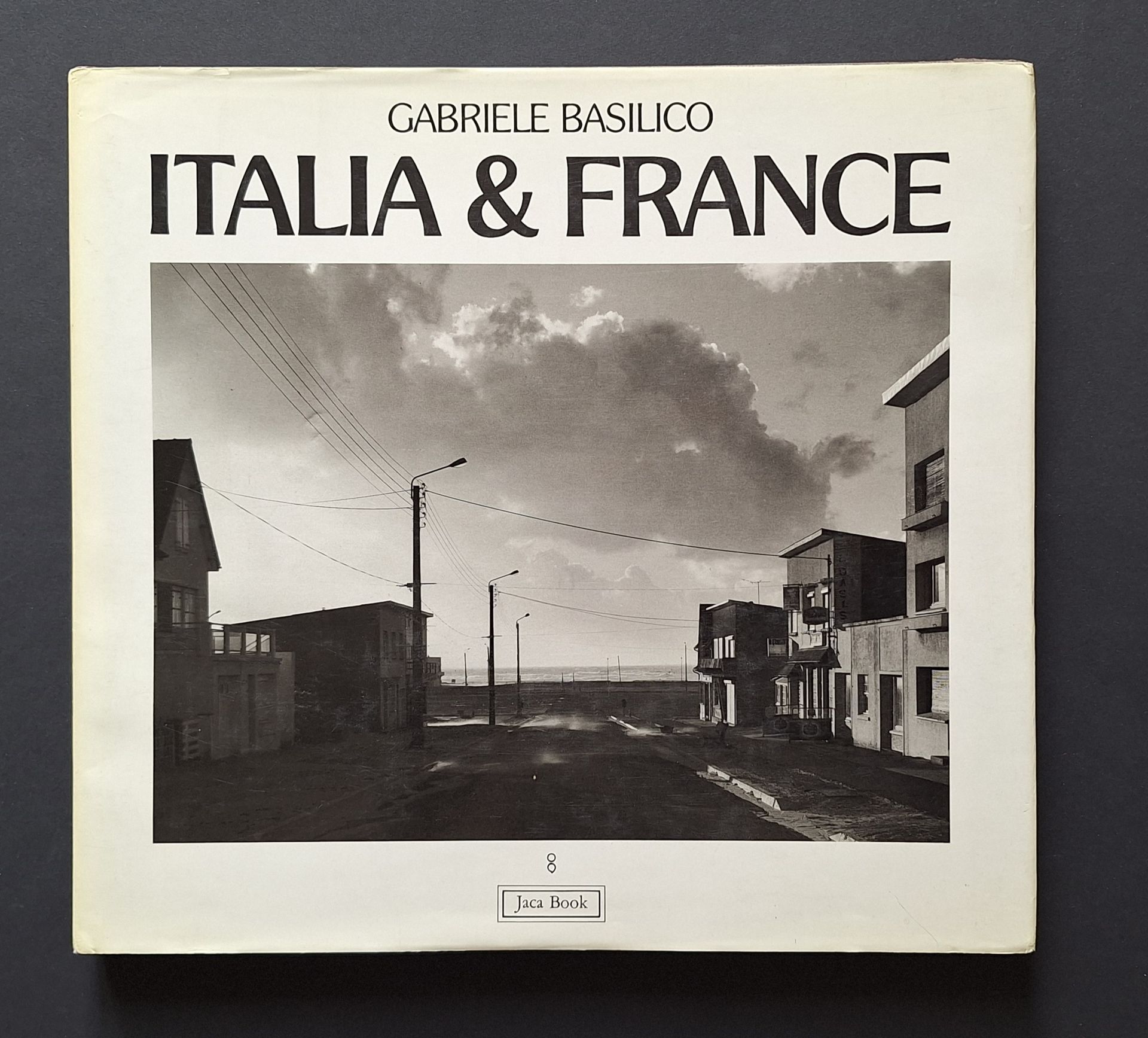 BASILICO, GABRIELE (1944-2013)
Italia & France, Vedute 1978-1985 Vues.
Editoriale Jaca Book (Punto e Virgola, 8), Milan, 1986. 
In-4 (28 x 31 cm). Édition originale réalisée sous la direction de Giovanni Chiaramonte. 150 pp. 104 photographies en noir et blanc pleine page; texte en français et en italien de Carlo Bertelli et entretien de Gabriele Basilico avec Giovanni Chiaramonte. Reliure d’éditeur cartonnée noire sous jaquette illustrée.