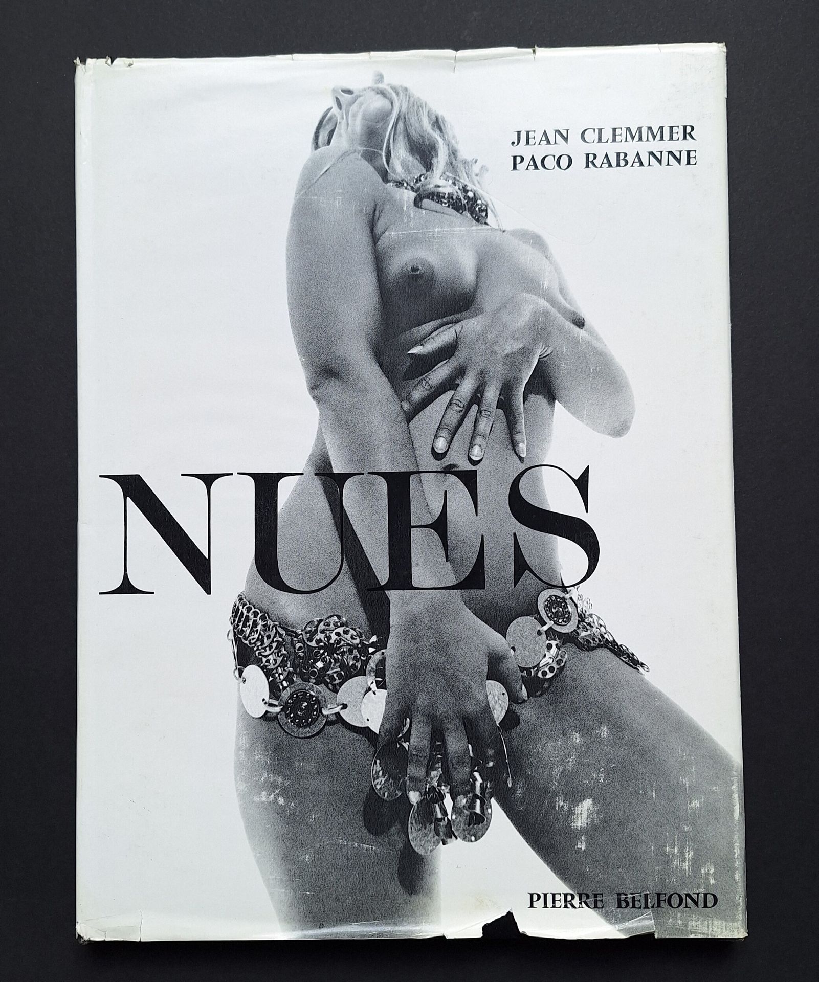 CLEMMER, JEAN (1926-2001)
PACO RABANNE (1934)
Nues.
Pierre Belfond, 1969.
In-4 (35,5 x 27 cm). Édition originale. Cartonnage noir avec titre doré sous jaquette illustrée avec déchirures (jaquette rhodoïd manquante).