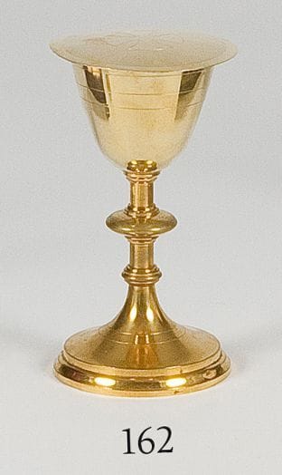 Calice et sa patène en vermeil, le piédouche en laiton gravés de rangs de filets sur la coupe et le pied, dans son coffret.Paris XIXe siècle. Poinçon minerve.Poids brut : 125 g
