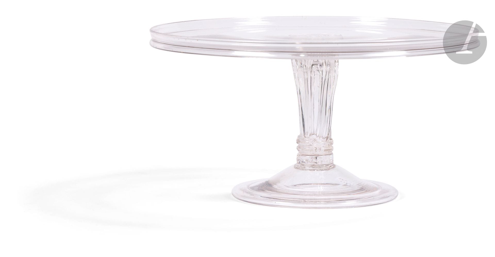 Crystal or Tazza top edged with a gallery. The leg is ribbed. The foot is hemmed in the shape of a dome, topped with a ringed bow.
England, 18th century. 
H.: 18cm, D.: 28cm
See Glass in 18th century England The footed salver by Keith Kelsall 1989