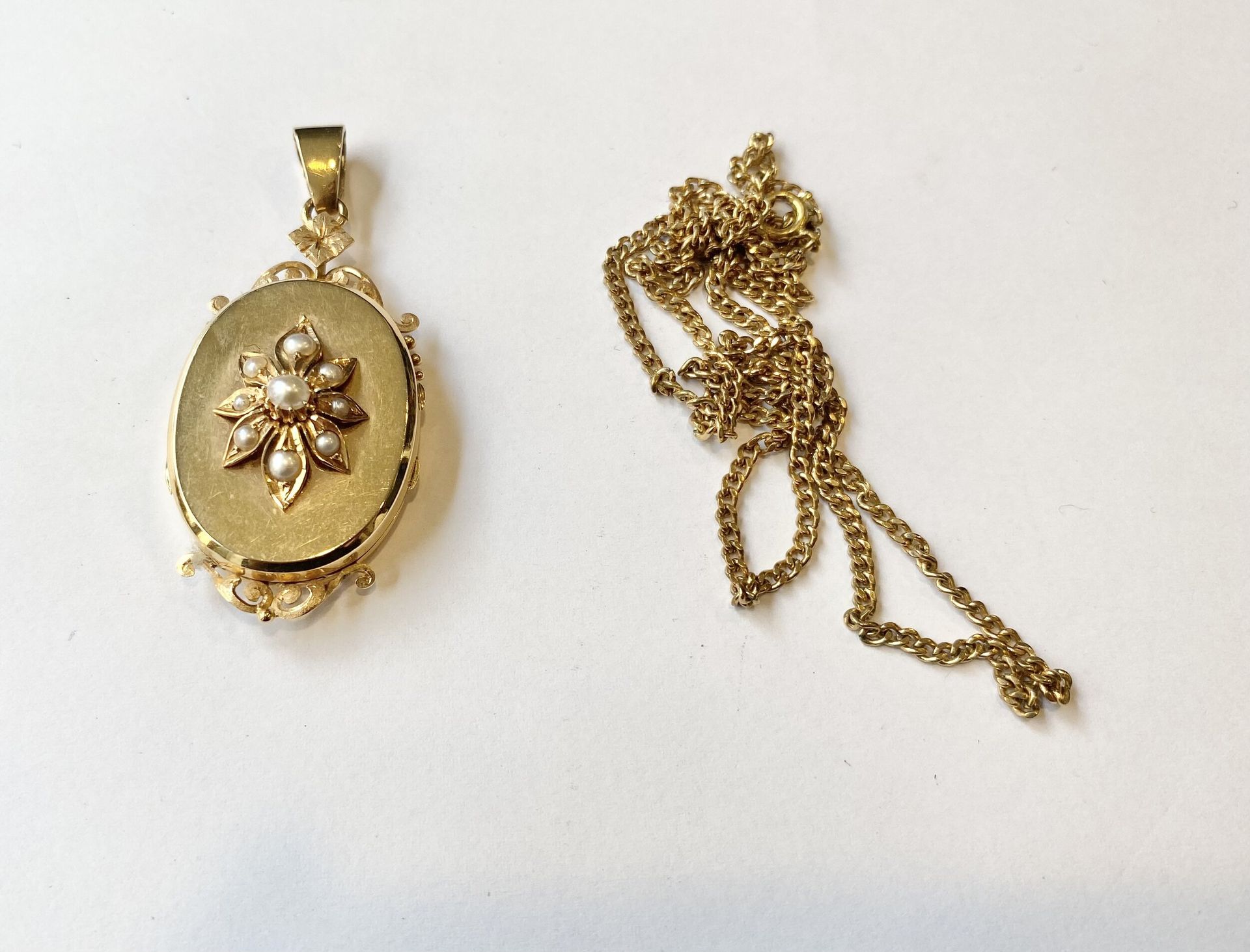 Yellow gold 750/°°° photo pendant and bangle with flower and pearl motifs. Gross weight of pendant (with glass). : 14.25 g Gross weight of bracelet. : 14.86 g Joint 375/°°° yellow gold chain Weight. : 6,2 g