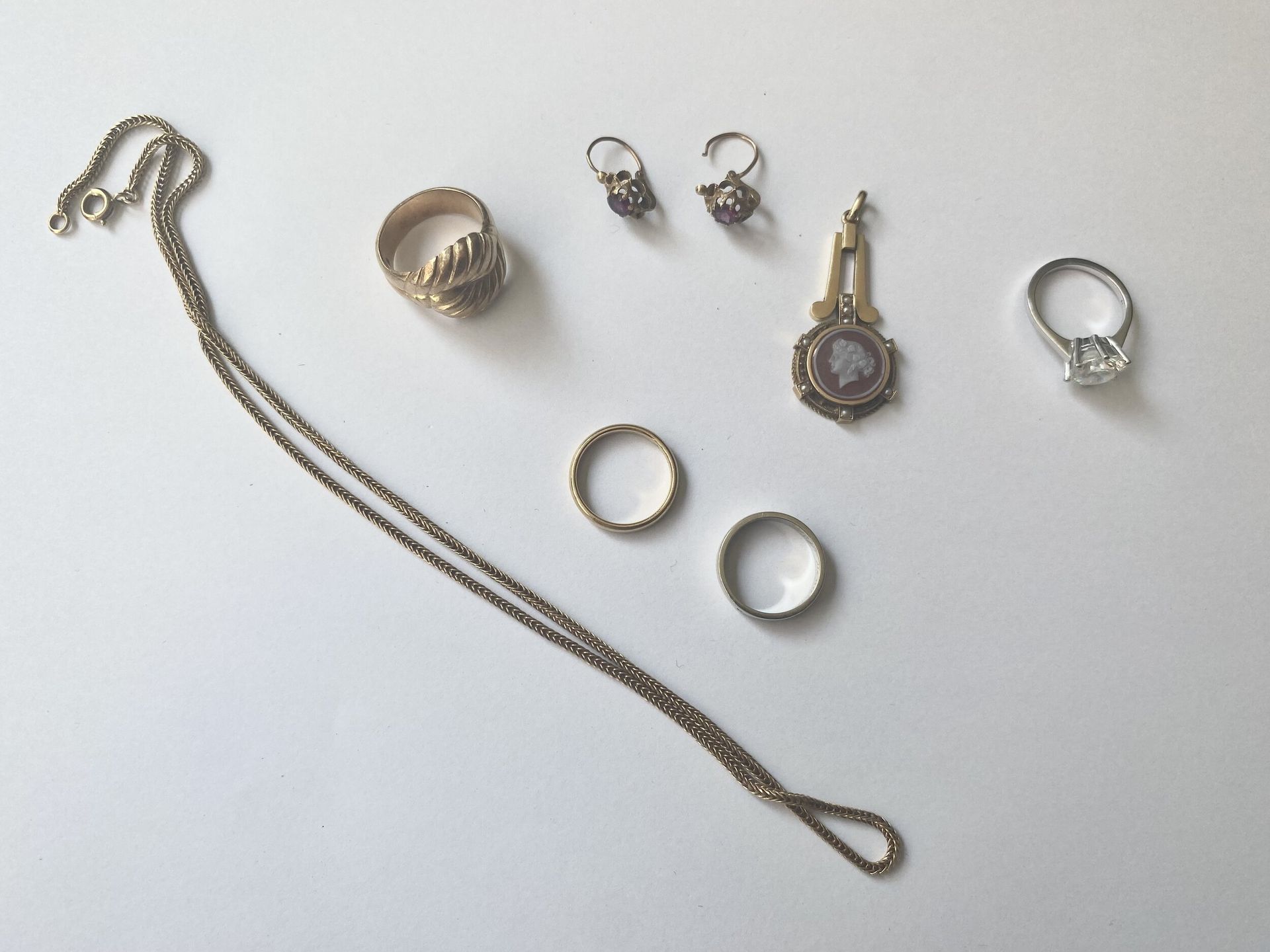 Lot de bijoux en or 750/°°°. 
- Une chaine en mailles tressées, une bague et deux alliances (dont une en or blanc). 
Poids. : 31,53 g 
- Un médaillon retenant un camé, une bague en or blanc, une paire de pendants. 
Poids brut : 10,2 g