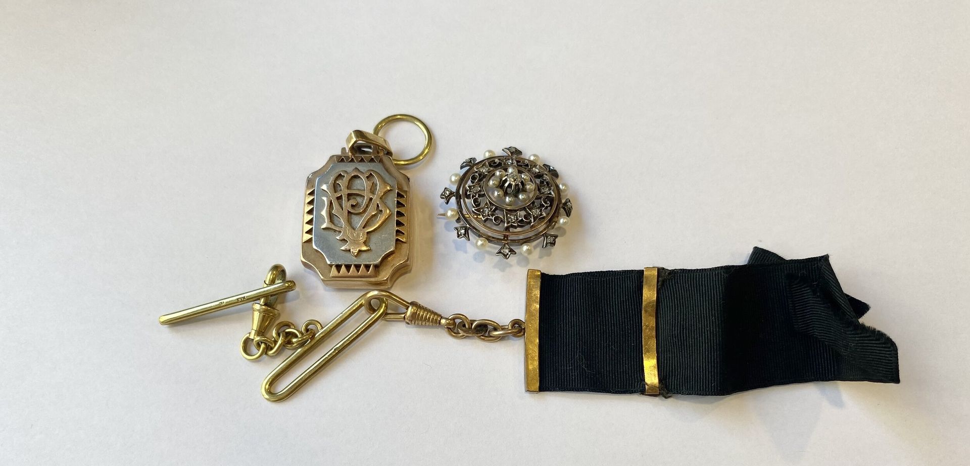 Gold lot Round brooch 585/°°° set with diamonds and small pearls. Gross weight 7.78 g 750/°°° gold pendant with glass and 750/°°°° gold and fabric chain. Gross weight : 33,38 g