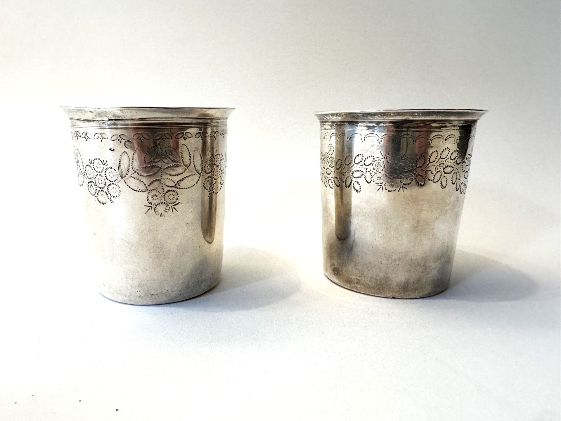 FRANCE 1818 - 1838. 
Paire de gobelets en argent à décor de fleurs et feuilles gravées. 
Poinçon Vieillard, Paris titre 1. Poinçon d orfèvre P.F. 
Poids. : 150 g 
Haut.: 8 cm