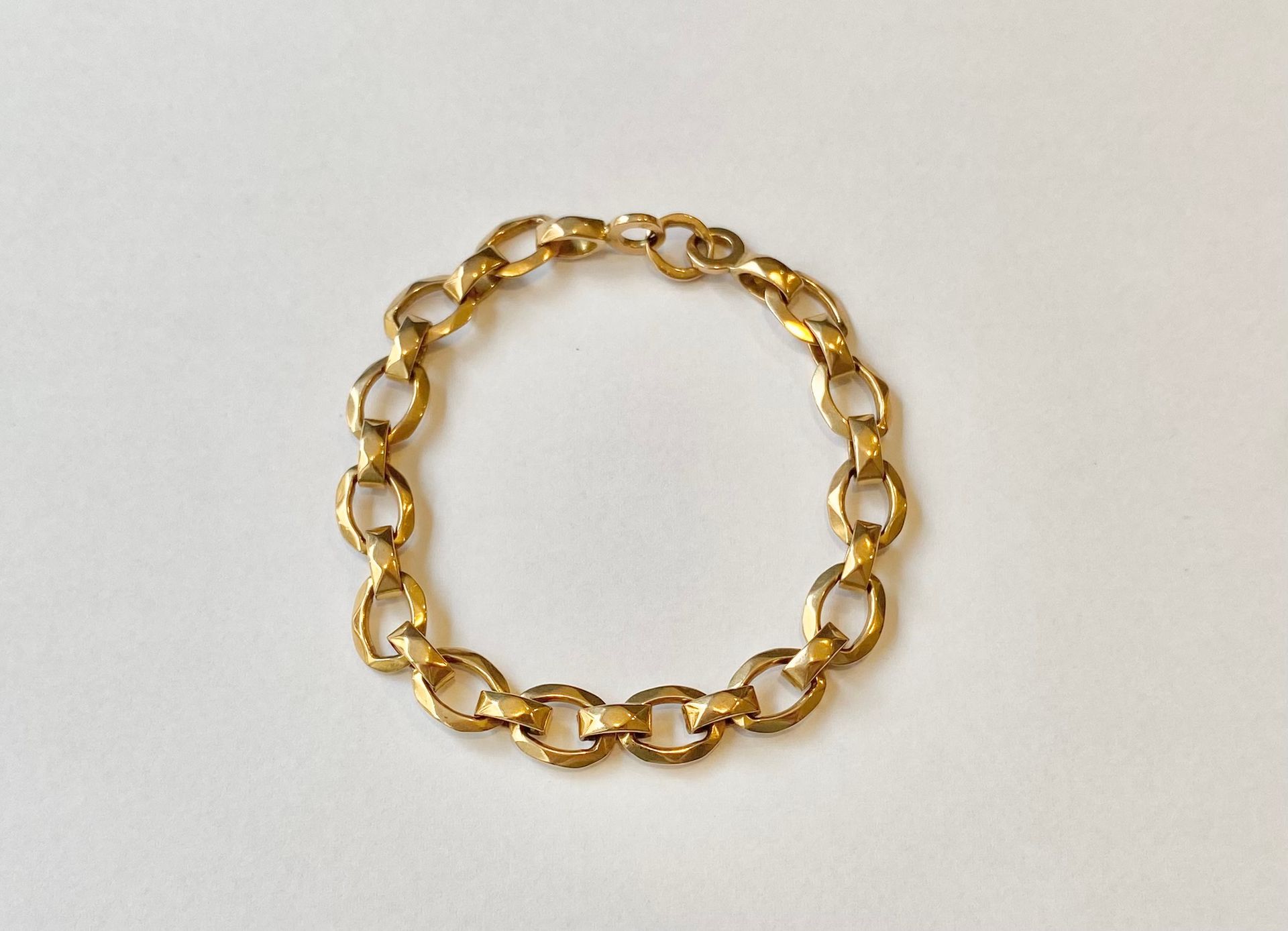 Bracelet articulé en or rose 750/°°° en mailles facettées. 
Poids : 18 g 
Manque le fermoir