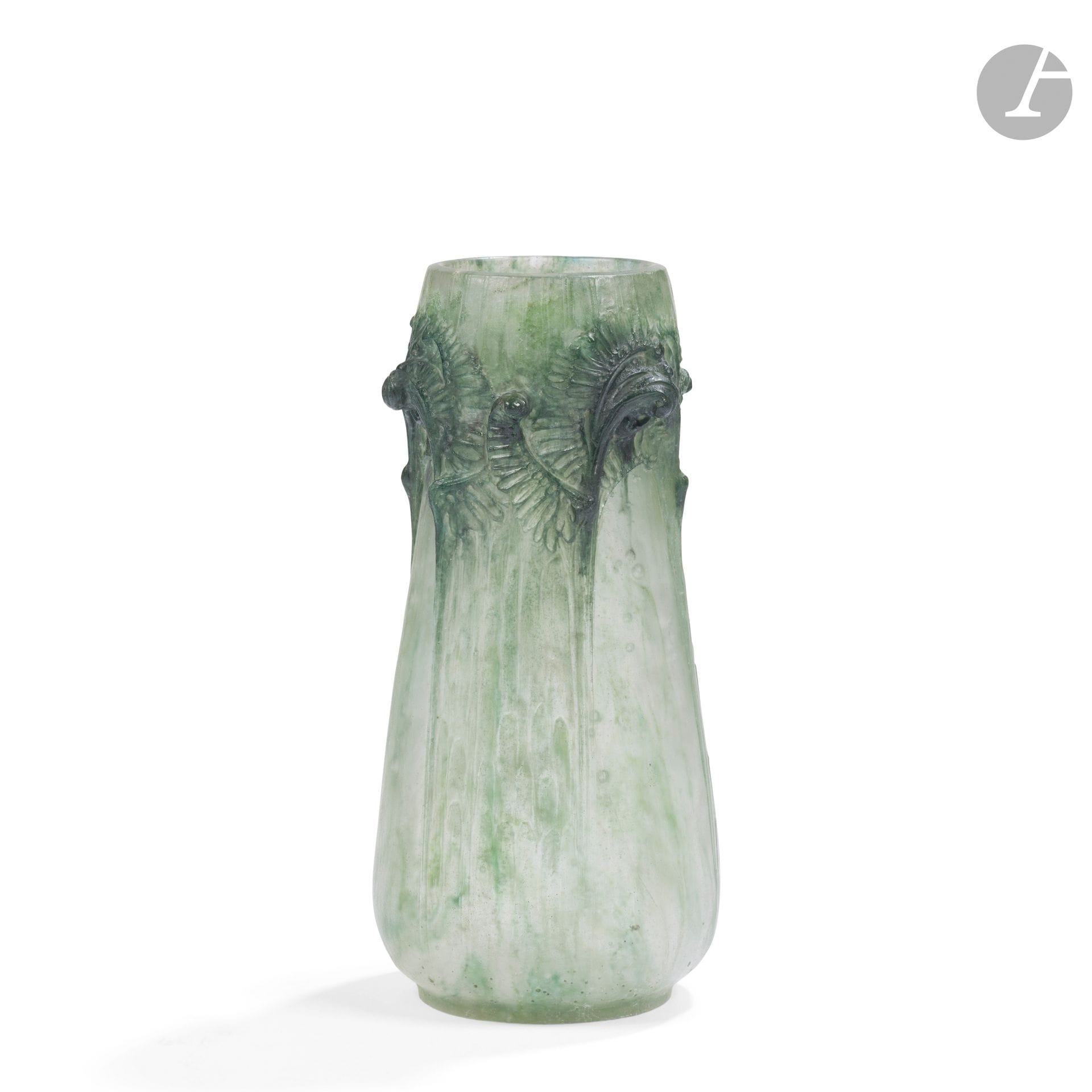 FRANÇOIS ÉMILE DÉCORCHEMONT (1880-1971)
Vase fougères en hauteur, le modèle créé en [1913] et diffusé jusqu'en [1914], réputé avoir été édité à 7 exemplaires
Vase piriforme évoquant une coloquinte ; le décor titre en haut-relief. Épreuve en pâte de verre polychrome ; vert d'eau nuancé de vert foncé, la panse bullée évoquant la rosée du matin. Deux importantes fêlures (stoppées) démarrant sous la base possiblement lors de l'élaboration de la pièce, infimes égrenures en pourtour du col, un petit éclat au talon. Marquée du cachet de l'artiste vers la base. H. 23 cm

Collections publiques :
Kitazawa Museum of Art, Tokyo - Un modèle identique (variante de couleurs) est conservé dans cette institution.

Bibliographie : 
Véronique Ayroles - François Décorchemont - Maître de la pâte de verre - Éditions Norma, Paris, 2006. Modèle référencé sous le n° 46 à la page 236, des variantes de couleurs reproduites page 89 et 237.