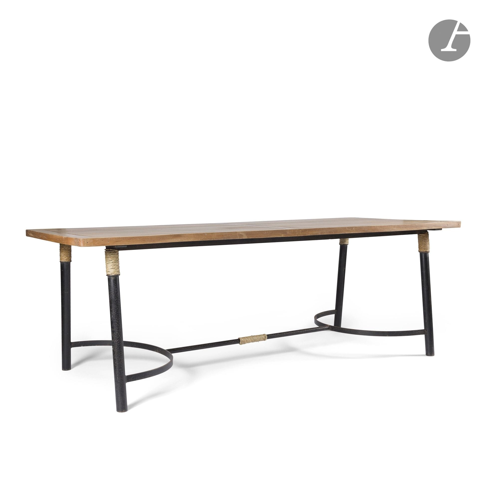 GALERIE MAISON ET JARDIN - GILLES SERMADIRAS DE POUZOLS DE LILE (1909-2007) FONDATEUR ET DIRECTEUR ARTISTIQUE
Table rectangulaire de salle à manger. Les quatre pieds en métal tubulaire laqué noir, chacun chapeauté d'un cordage, réunis par une entretoise en métal plat et métal tubulaire également laqué noir. Le plateau, aux angles légèrement arrondis, en épaisses lattes de chêne au montage apparent à la manière d'un parquetage. Années 1950-1960. Manque la ceinture en métal du pourtour du plateau. H. 75,5 cm - L. 220 cm - l. 90 cm 

Provenance : 
D'un importante décoration de la Galerie Maison et Jardin restée jusqu'à aujourd'hui dans la même famille.