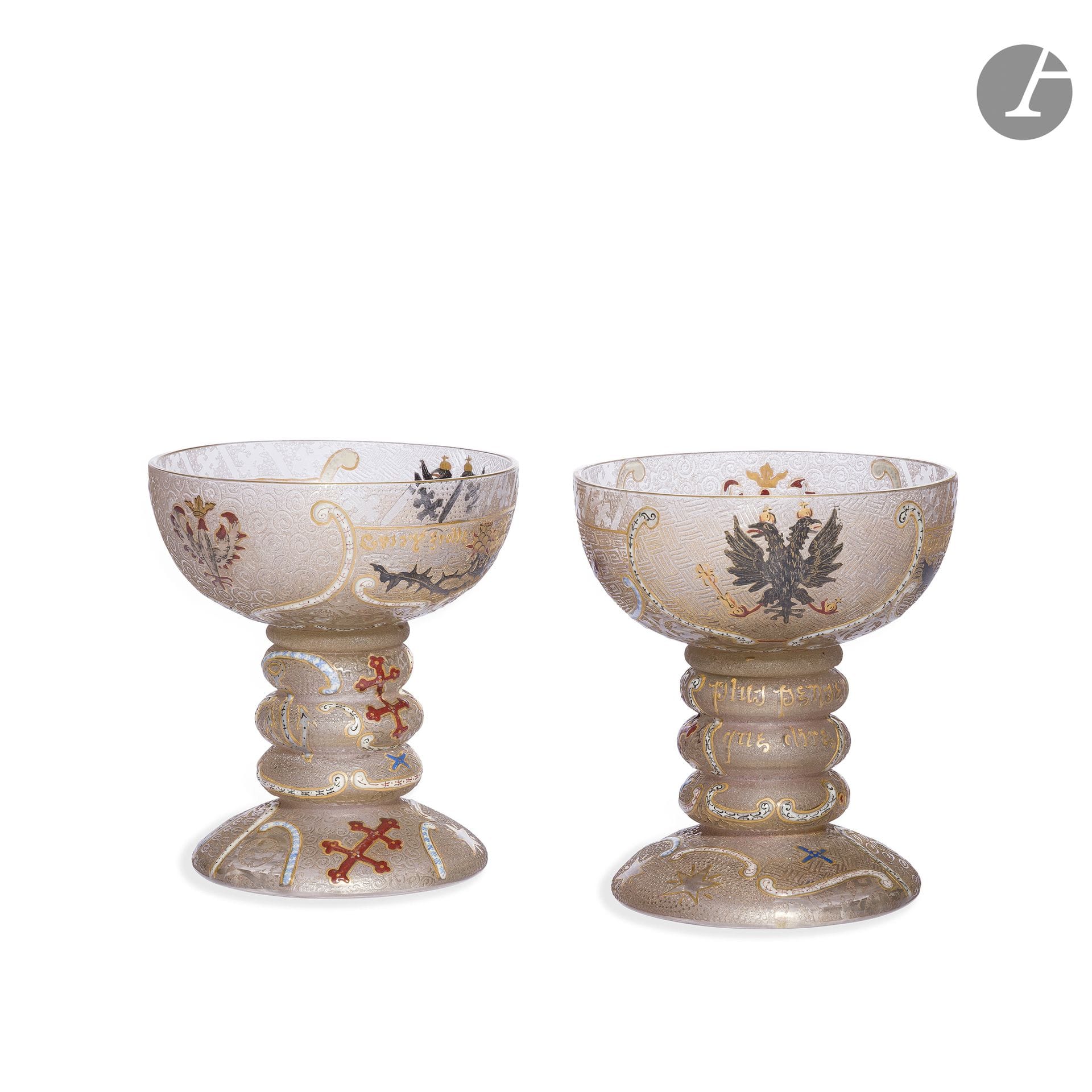 DAUM NANCY 
Qui s'y frotte s'y pique - Plus penser que dire - Les fidèles lorrains, 1898, œuvres célébrant l'Alliance franco-russe initiée en 1892
Rare paire de vases, de type Calice, parlants et formant coupe à Champagne. Épreuves en verre clair. Les parties hautes aux décors, dans quatre réserves, symbolisant la Lorraine et la Russie (Chardon, Aigle bicéphales, Croix de Lorraine, Aigle couronné) réalisés aux émaux polychromes, le proverbe - Qui s'y frotte s'y pique - dégagés à l'acide et rehaussés à l'or, et Les fidèles lorrains figurant dans des rubans émaillés, les autres rubans évoquant des caractères cyrilliques - Le tout sur des fonds de motifs géométriques dégagé à l'acide. L'expression - Plus penser que dire - dégagée à l'acide et rehaussée à l'or sur les jambes à trois renflements, également accompagnée de rubans émaillés. Les bases, bombées et circulaires, aux motifs de Croix de Lorraine, d'une ancre et d'étoiles indifféremment traités à l'émail ou dégagés à l'acide et achevés à l'or.  Signé DAUM Nancy à la Croix de Lorraine, à l'émail rouge au revers. H. 10,5 cm

Bibliographie :
- Gustav E. Pazaurek - Modern Gläser - Éditions Hermann Seeman Nachgolger, Leipzig, vers 1900. Un modèle identique reproduit page 101.
- Noël Daum - Daum ; maîtres verriers - Éditions Denoël/Édita, Paris/Lausanne, 1980. Un modèle identique reproduit page 41.