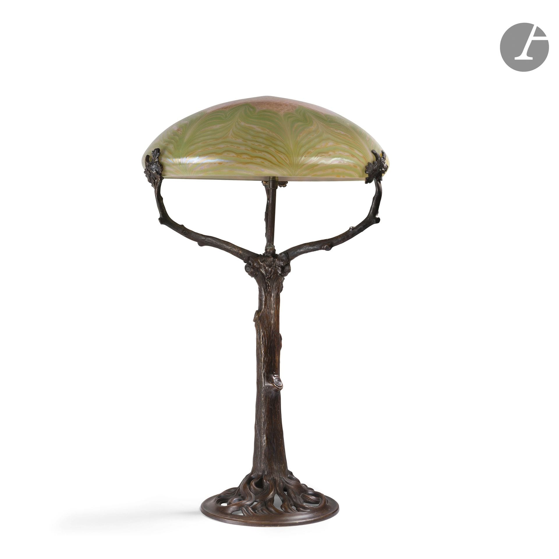 JOHANN LOETZ WITWE (ATTRIBUÉ À) & TRAVAIL FRANÇAIS DU XXe SIÈCLE
Lampe de salon ; les deux parties appairées non d'origine. Le pied figurant un arbre et réalisé en bronze à patine brune. L'abat-jour en verre irisé. H. 60 cm