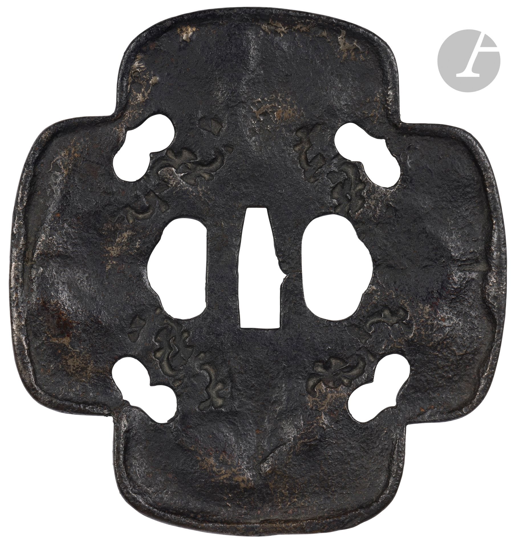 Large iron tsuba in kurikomi mokkô gata form, Japan, early Edo period (1603-1868)
In this kurikomi mokkô form, each inner corner is decorated with a sukashi inome (boar's eye). The mimi is of the uchikaeshi (forge-raised edges) type, heavily hammered in the tembo style with the use of kokuin (hot stamps) and brass inlays. The hot stamps imitate the wormholes in the wood. The various techniques used in making this tsuba are characteristic of the Saotome Tembo school.
15.2 x 14.3 cm

Provenance :
Former Nourhan Manoukian collection (1906-1993). By descent.