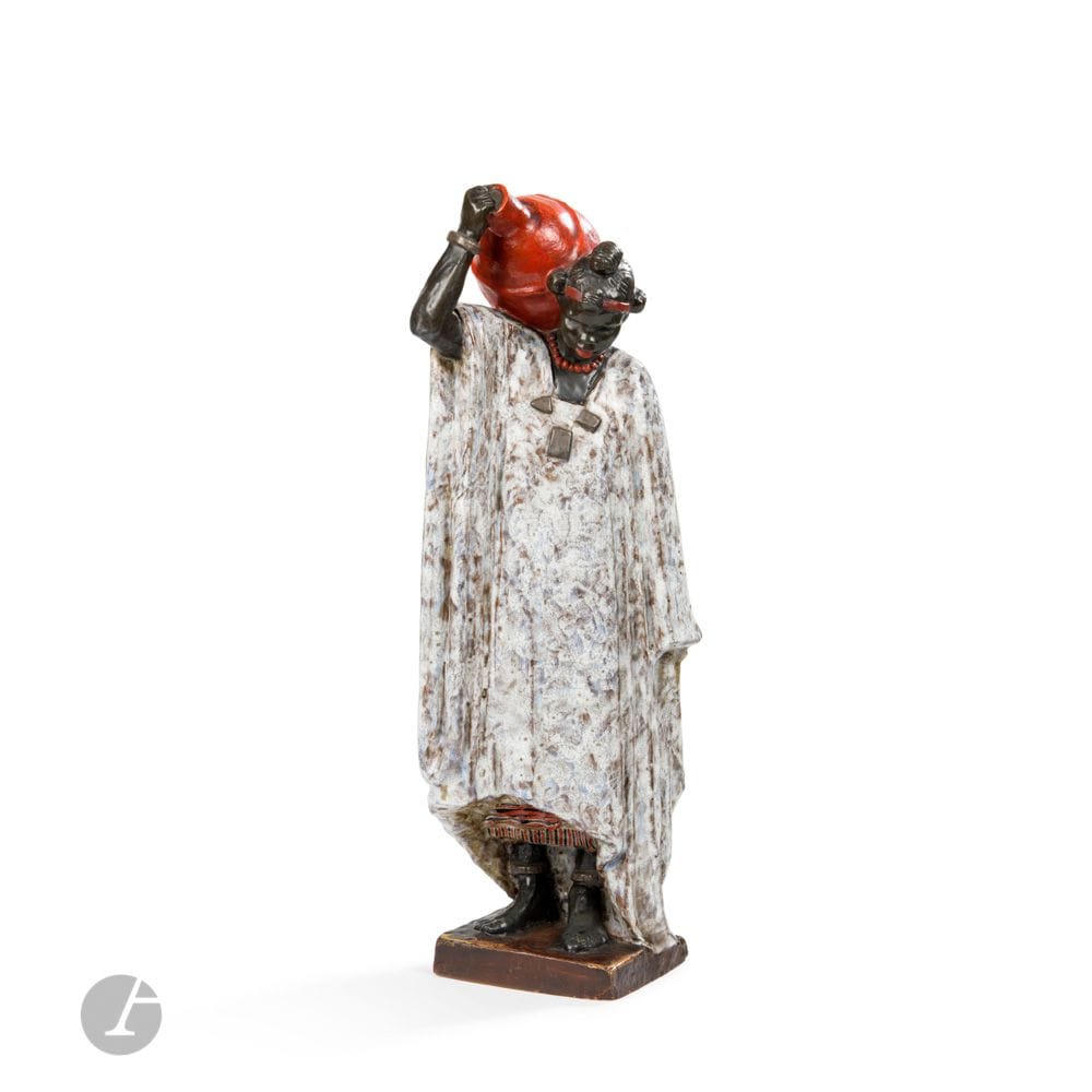 ANNA QUINQUAUD (1890-1984) SCULPTEURE & MANUFACTURE NATIONALE DE SÈVRES
Femme porteuse d’eau Songoï, dite aussi La porteuse d’eau de Tombouctou, ou Négresse à l’amphore, le modèle conçu vers [1925], le plâtre du modèle présenté à la Galerie d’Art contemporain (Paris) en 1926, l’édition en grès tendre à seulement 7 exemplaires réalisés entre1930 et 1933, la seule épreuve en grès tendre émaillé polychrome connue à ce jour
Sculpture.
Épreuve en grès tendre émaillé polychrome.
Un éclat sur un angle inférieur de la terrasse.
Signée et datée A. QUINQUAUD 1925 sur la terrasse, porte le cachet-date (date non lisible) de la Manufacture Nationale de SÈVRES et la mention AR et le tampon GT (pour grès tendre) sur la partie latérale de la terrasse.
Hauteur: 47,5cm
Terrasse: 11x12cm

Historique:
Anna Quinquaud signa un contrat avec la Manufacture Nationale de Sèvres le 16 août 1927 pour l’édition en céramique de la sculpture Femme porteuse d’eau Songoï. Seulement 7 épreuves en grès tendre furent réalisées; 2 en 1930, 2 en 1931, et 3 en 1933 (sans distinction entre les versions émaillée et non émaillées). Neuf épreuves en biscuit furent également réalisées; 2 en 1927 et 7 en 1928.  Le moule fut supprimé en 1942 sous la direction de Guillaume Jeanneau, alors directeur de la manufacture. Au total, six sculptures différentes d’Anna Quinquaud furent éditées en céramique par la Manufacture Nationale de Sèvres, entre les années 1930 et les années 1940, toutes dans des éditions extrêmement limitées.
Le plâtre de notre modèle de sculpture fut par ailleurs présenté pour la première fois lors de l’exposition «Mes travaux de voyage» organisée à Paris en 1926 – où furent exposées les œuvres de l’artiste à l’issue de son premier voyage en Afrique.

Collection publique:
Manufacture Nationale de Sèvres – Une épreuve en plâtre polychrome et une épreuve en biscuit de porcelaine de notre modèle de sculpture sont conservées dans les collections de cette institution sous le numéros d’inventaire 2012.D.643 et PL-C488.  

Exposition:
- Anna Quinquaud: Mes travaux de voyage – Galerie d’art contemporain, Paris, du 30 octobre au 13 novembre 1926. Une épreuve enplâtre de notre modèle de sculpture exposée lors de cette manifestation (N°11). 
- Les grès de Sèvres au XXe siècle – Galerie Yves Gastou, Paris, du 17 mai au 9 juin 1990. Une épreuve en grès de la Négresse à l’amphore exposée lors de cette manifestation. 

Bibliographie: 
- Les œuvres de la Manufacture de Sèvres 1738-1932, volume II, la sculpture moderne – Éditions de la manufacture, Sèvres, vers 1932. Une épreuve en grès tendre non polychromé ou en biscuit reproduite planche 42 sous le N°1397.
- Les grès de Sèvres au XXe siècle – Catalogue de l’exposition organisée à la Galerie Yves Gastou, Paris (17 mai – 9 juin 1990), Éditions de la galerie, Paris, 1990. Une épreuve en grès de la Négresse à l’amphore citée parmi les œuvres exposées.
- Jean-Paul Midant – Sèvres – La Manufacture au XXème Siècle – Michel Aveline éditeur, 1992. Variante en biscuit de porcelaine reproduite page 95.
- Anne Doridou-Heim – Anna Quinquaud, exploratrice, sculptrice – Voyage dans les années 30 – Somogy Éditions d’Art, Paris, 2011. L’épreuve en plâtre polychromé de notre sculpture Femme porteuse d’eau Songoï reproduite pages 68 et 159; le modèle référencé parmi les éditions de la Manufacture Nationale de Sèvres page 158. 
- Marie-Josèphe Conchon – Thérèse et Anna Quinquaud, la sculpture en partage – Les Ardents Éditeur, Limoges, 2022. Une épreuve en plâtre de notre modèle de sculpture reproduite page 105.