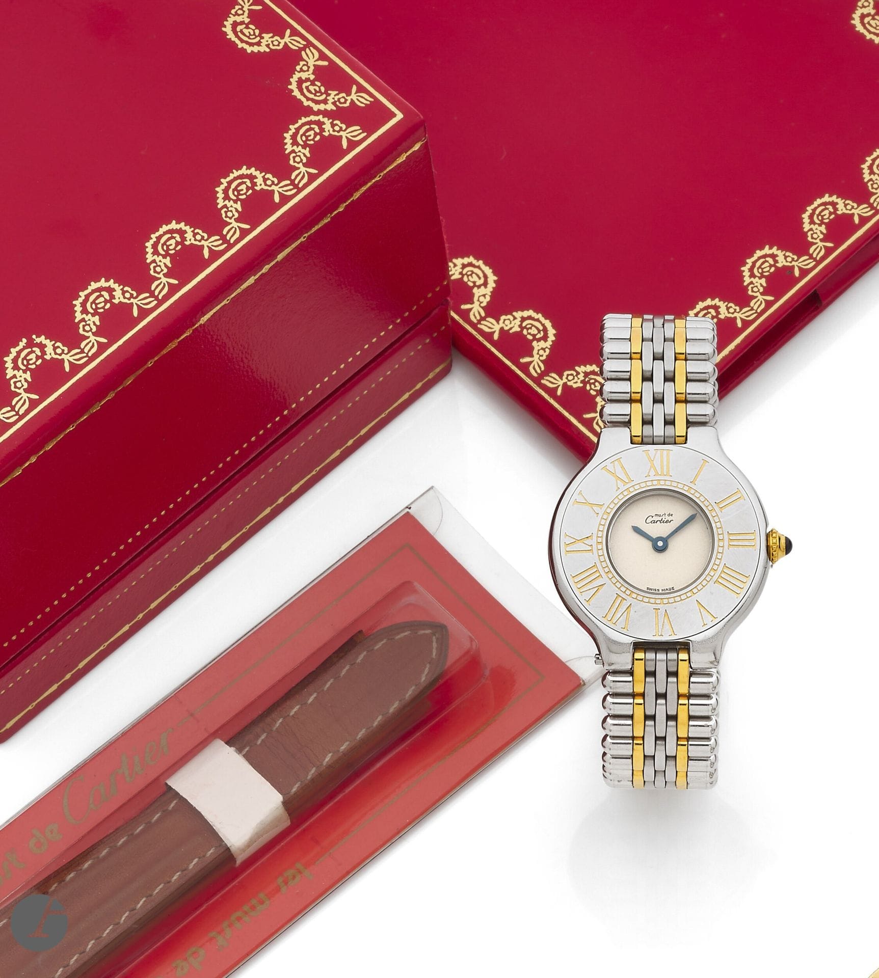 CARTIER 
MUST 21 
Montre bracelet de dame en acier et métal doré. 
Boîtier : tonneau en acier, fermeture à vis, lunette plate avec index chiffres romains gravés. 
Cadran : argenté, aiguilles glaive en acier bleui. 
Mouvement : quartz. 
Bracelet : acier, maillons cylindriques, inter maillons métal doré, boucle triple déployante en acier, signée. 
Signée et numérotée A10273. Diam. 28 mm 
Avec : écrin, service Cartier (2000), maillons supplémentaires (2,4 cm), 2 bracelets cuir (usés), boucle dépliante en acier Cartier, un bracelet cuir neuf Cartier.