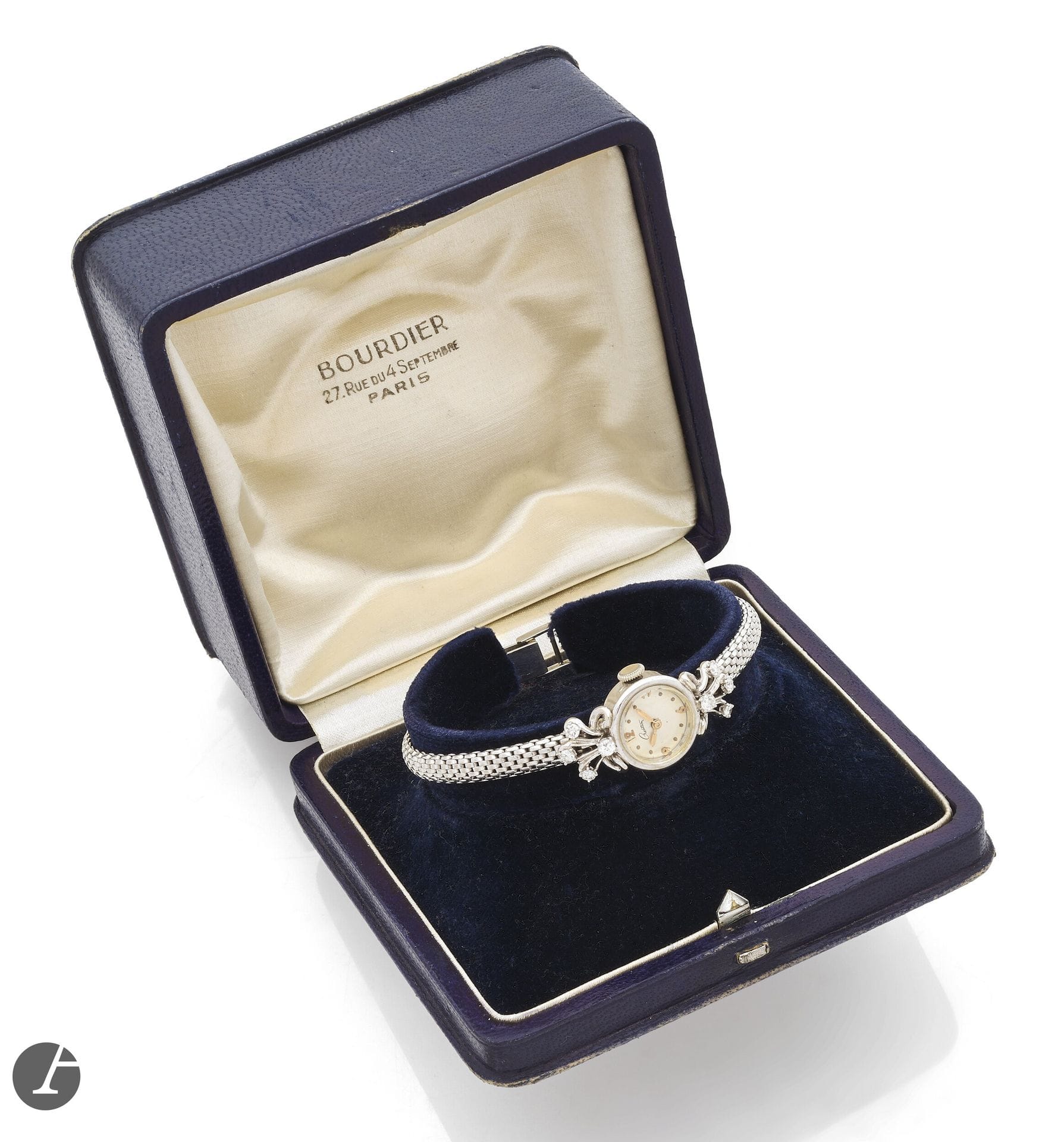 TRAVAIL FRANÇAIS 
ANNÉES 40 
Petite montre bracelet de dame en or gris 18K (750 millièmes) et petits diamants. 
Boîtier : rond, attaches fleuries, piquées de petits diamants.
Cadran : signé Création. 
Mouvement : mécanique, signé Rodania. 
Bracelet : souple en or gris, type Tubogas, boucle simple. 
Diam. 15 mm Longueur : 16,5 cm. Poids brut : 24,4 g  Avec : écrin, signé Bourdier, 27 rue du 4 Septembre, Paris.