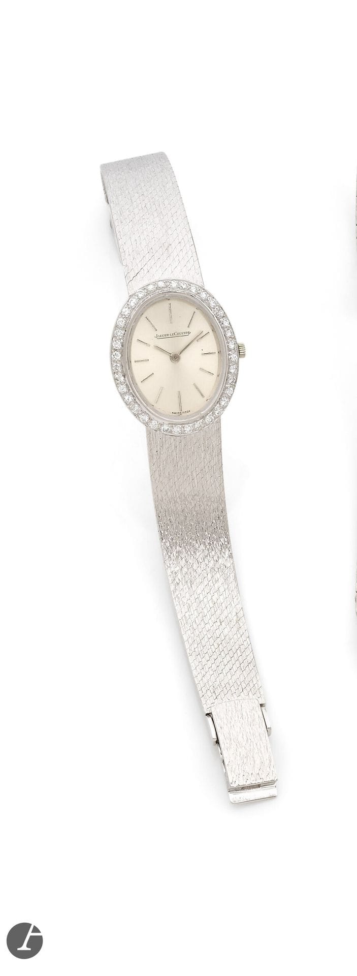 JAEGER LECOULTRE  
ANNÉES 60 
Montre bracelet de dame en or gris 18K (750) et diamants, poinçon suisse de provenance étrangère. 
Boîtier : ovale, lunette sertie de diamants. 
Cadran : argenté, index bâton appliqués. 
Mouvement : mécanique. 
Bracelet : intégré en or gris satiné, boucle simple, non signée.  
Numérotée 1048998. Dim. 28 x 23 mm Longueur : 15,5 cm. Poids brut : 45,2 g