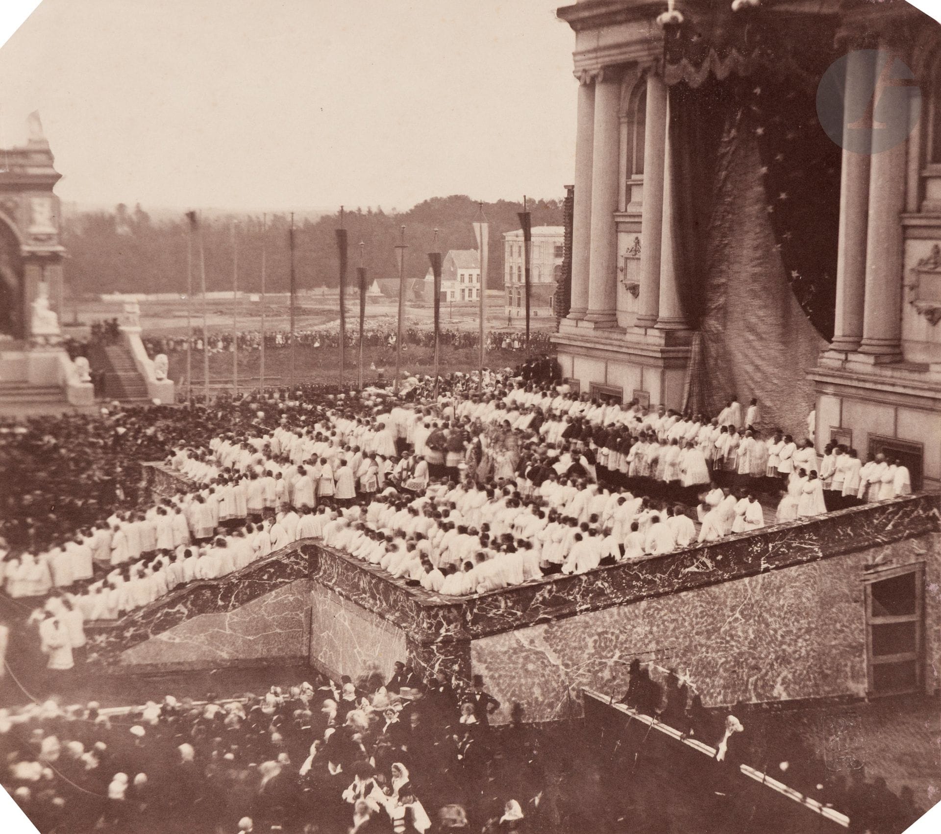 Louis Dubois de Nehaut (dit Le Chevalier Dubois de Nehaut) (1799-1872)
Cérémonie du 25e anniversaire du règne de Léopold 1er à l’église Saint-Joseph. Bruxelles, 21 juillet 1856. 
Épreuve sur papier salé-albuminé, d’après négatif verre au collodion, contrecollée sur carton fin. Timbre sec du photographe en bas à droite. Signature et dédicace à l’encre « Offert à Mme la Comtesse Louis Duchastel » sur le montage en bas à droite. 
21 x 23 cm

 En juillet 1856, Bruxelles est le théâtre de célébrations organisées à l’occasion des vingt-cinq ans de règne du roi Léopold Ier. Devenu membre de la Société française de photographie l’année précédente, Louis-Pierre-Théophile Dubois de Nehaut réalise à cette occasion ce qui sera considéré comme l’une des premières campagnes photographiques méthodiques visant à restituer un événement dans ce qu’il peut avoir de fugace. Louis Humbert de Molard, alors sur place aux côtés du photographe belge, rend compte de cette mission dans les pages du Bulletin de la SFP (tome 2, 1856, p. 311-314), précisant l’emploi alterné du collodion humide « sur les masses tumultueuses du dehors » et du collodion sec (procédé Taupenot) en fonction de la mobilité des sujets photographiés. Une soixantaine de négatifs sont réalisés durant ces trois jours. Cependant, les tirages en circulation – sinon produits – sont rares, et l’ensemble le plus important d’épreuves (34) dont nous avons connaissance est conservé dans les collections de la Bibliothèque royale de Belgique.
