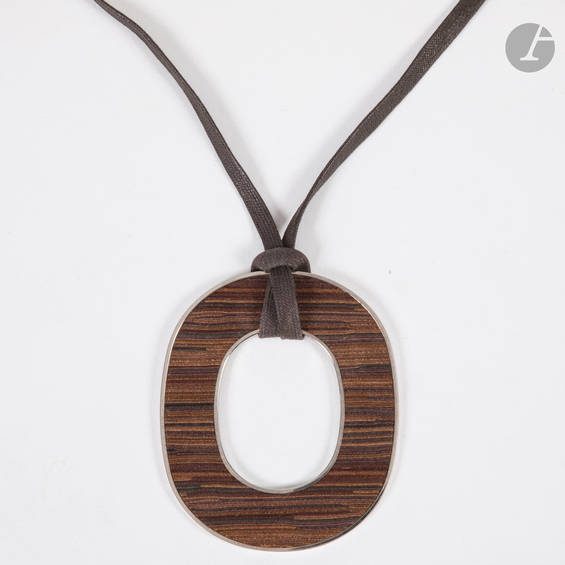 HERMÈS PARIS
Silver-plated metal and brown suede calfskin pendant. Signed. H : 9 cm