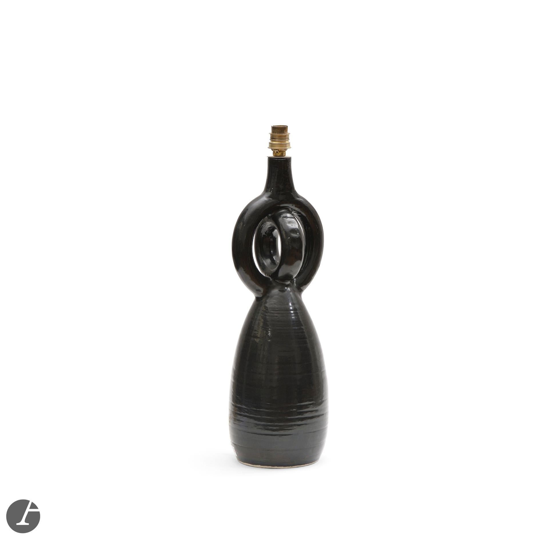 GEORGES JOUVE (1910-1964)& JEANNE PIERLOT (1917-1988) – ANCIENNE COLLECTION FAMILLE PIERLOT
Sans titre, vers 1953-1954
Pied de lampe à double anneaux.
Épreuve en céramique émaillé noir.
Œuvre probablement réalisée en collaboration avec Dimitri Jakob Müller.
Marqué RATILLY à l’intérieur de la base.
Hauteurcéramique seule: 44cm

Provenance:
- Collection Famille Pierlot.
- Collection privée.

Remerciements:
Nous adressons nos plus vifs remerciements à Martin Pierlot, fils de Jeanne et Norbert Pierlot, pour les précieuses informations qu’il nous a livrées au sujet de cette œuvre et pour nous avoir confirmer que ce pied de lampe avait vraisemblablement été réalisé à «4 mains», celles de Georges Jouve et de Jeanne Pierlot, probablement aidés par Dimitri Jakob Müller, tourneur d’exception alors âgé de 19 ans, que Jouve avait amené au Château de Ratilly et qui deviendra un clown très célèbre par la suite.


Artiste indissociable de la renaissance de la céramique française de la seconde moitié du XXe siècle, Georges Jouve est à l’origine d’une œuvre avant-gardiste, marquée par la pureté formelle; des lignes simples, précises, justes et élégantes. Formé à l’École Boulle, les événements de la Seconde Guerre mondiale décidèrent de sa rencontre avec le matériau terre. Se réfugiant dans la Drôme, Jouve découvrit les traditions potières des villages de Nyons, connu pour sa production de santons, puis de Dieulefit. Durant ces temps troublés, de nombreux artistes furent dispersés à travers la France, dans l’incapacité d’exercer leur métier de formation – et donc de gagner leur vie. Ils se tournèrent alors vers la poterie, dont les ateliers étaient désertés, pour poursuivre leurs recherches plastiques. S’opéra ainsi durant le conflit et l’immédiat après-guerre un « retour à la terre », réponse à la déconstruction du monde – le recours à ce matériau brut et simple permettant une réintroduction de l’humain au cœur de leurs créations.
Introduit à la terre à Nyons, ses premières créations oscillèrent entre tradition locale et tendances modernes, preuves de son univers déjà en germe. Aussi, il adopta l’émaillage à l’alquifoux et commença par réaliser des sujets religieux, des miroirs ou encore des bénitiers – en s’alignant sur la tradition provençale.  À la fin du conflit, de retour à Paris où il installe son atelier, il travaille des pièces marquées par une richesse décorative en accord avec le style de l’époque, avant d’explorer de nouvelles formes la décennie suivante: des céramiques aux lignes simples, épurées et monochromes, ainsi que des pièces plus architecturées pour lesquelles il sera particulièrement célébré.
Dès ses premières recherches, Jouve affirme une personnalité et une approche de la céramique qui lui sont propres, en avance sur son temps, et qui marqueront toute une génération de céramistes. Son œuvre passe ainsi du figuratif à l’abstraction avant de se réorienter vers une simplification des volumes, associée à l’utilisation de couleurs vives caractéristiques. Très vite reconnu par ses pairs et par les décorateurs, son travail est mis en valeur dans la presse et présenté dans les plus grands salons – à l’instar du Salon des Artistes Décorateurs, du Salon des Arts Ménagers ou encore de la Triennale de Milan. Sa disparition prématurée mit un terme à une œuvre aujourd’hui considérée comme l’une des plus importantes dans l’art céramique français de l’après-guerre.