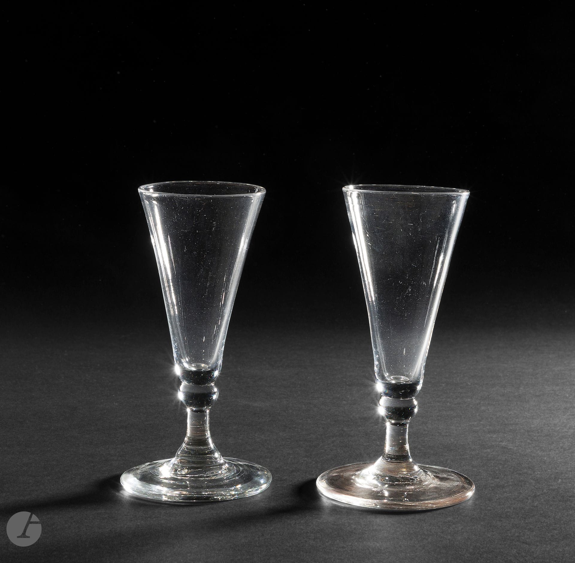Two crystal glasses. Ale glasses or champagne flutes. The leg is topped with a bow. 
England, 18th century. 
H. 14 cm