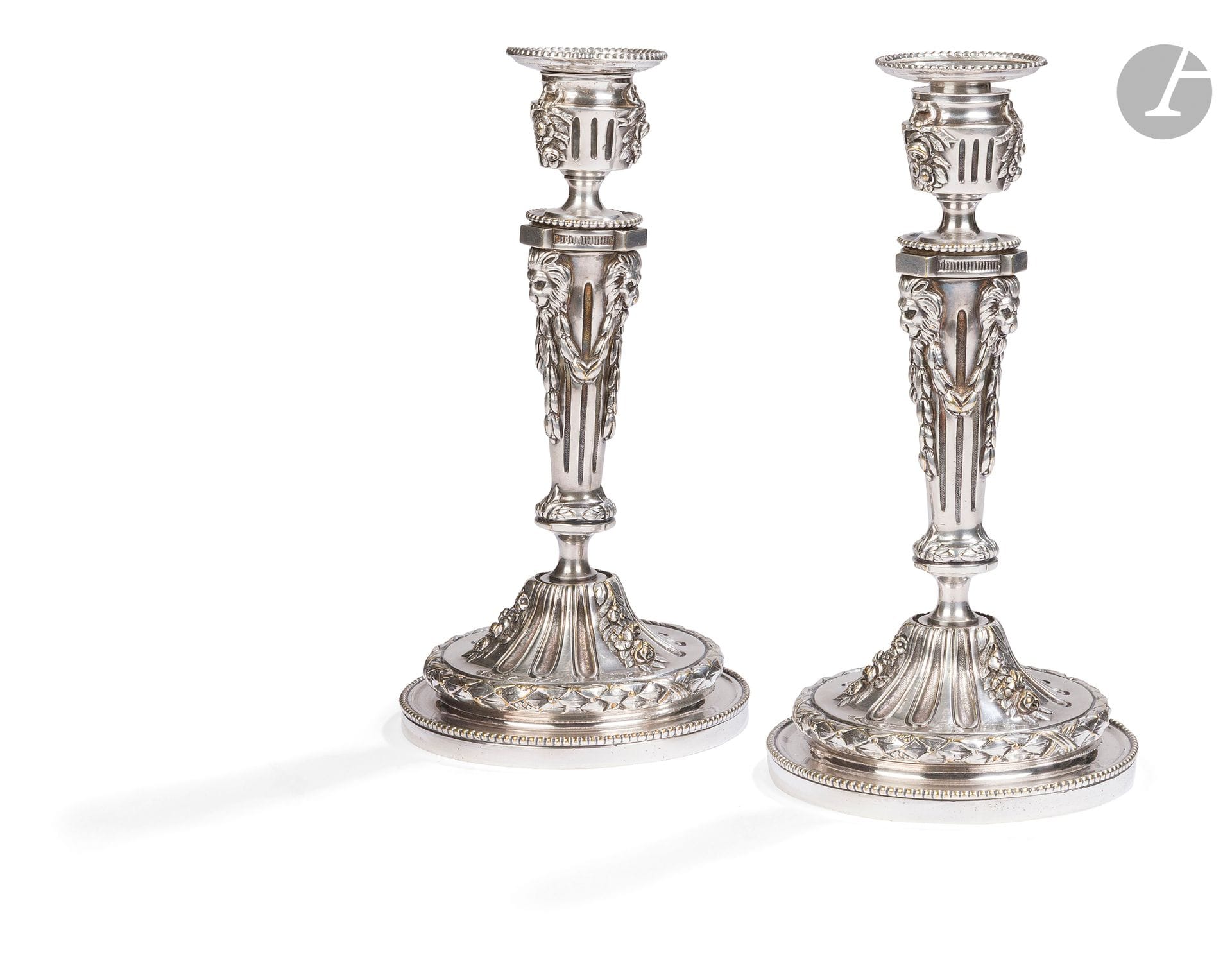 Pair of silver-plated bronze torches, the shaft with flutes and lion's heads, resting on a base with flower and foliage falls, laurel leaf and pearl frieze.
Louis XVI style, late 19th century.
H. Height : 28 cm
