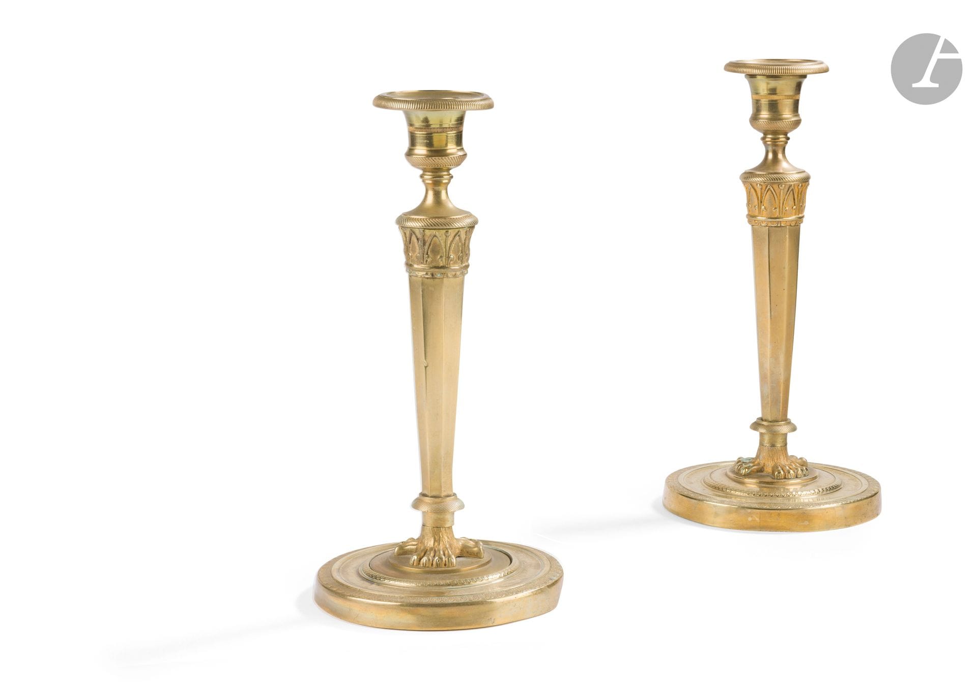 Pair of bronze torches (formerly gilded), the tapered shaft resting on a circular base with guilloché decoration; (accidents and restorations).
Empire period.
H. 26 cm