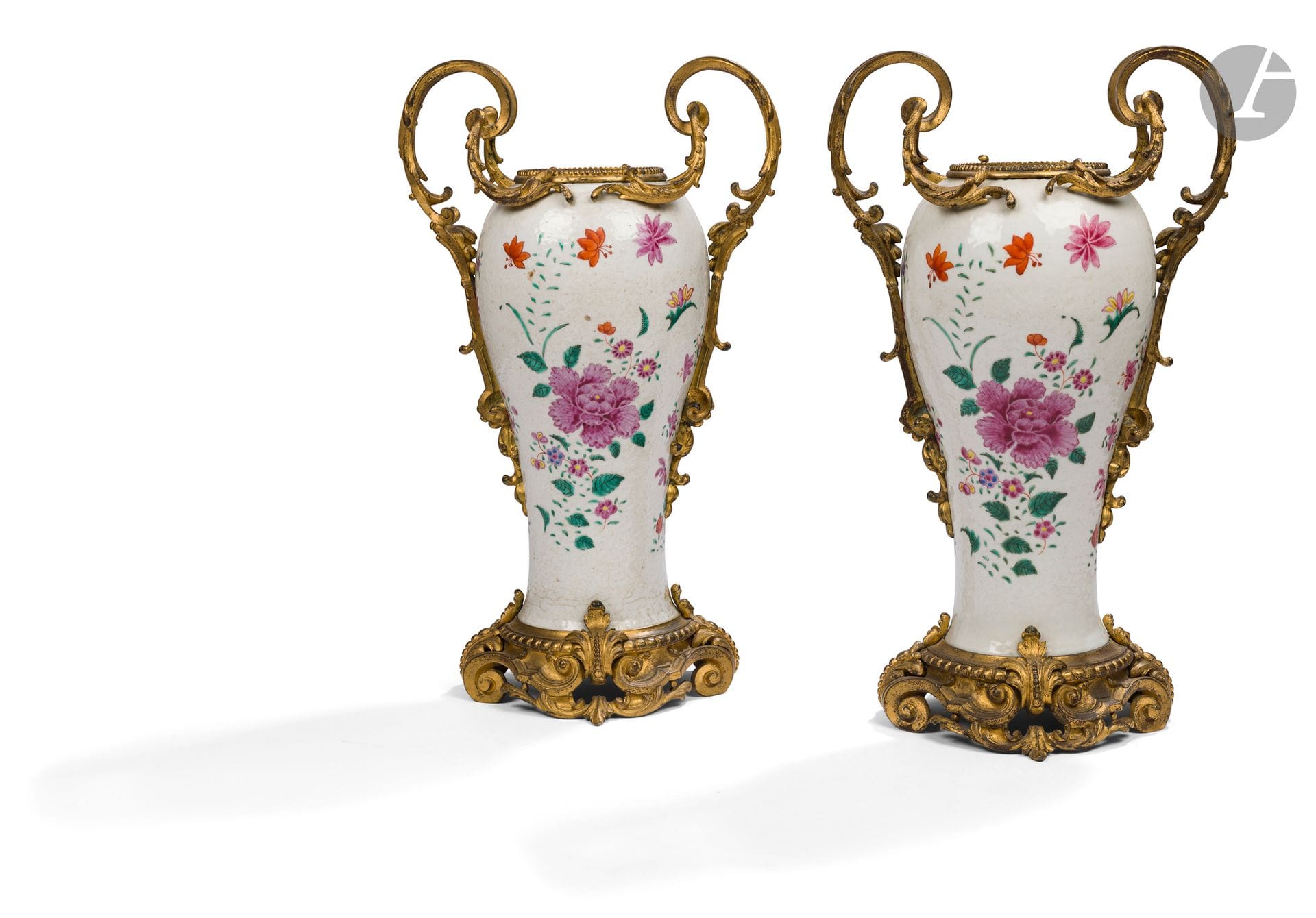 Paire de vases en porcelaine de Chine famille rose à monture de bronze doré à décor de feuillages stylisés et enroulements ; (manque probablement un couvercle ; usures).
Époque Napoléon III.
H. : 45 cm, L. : 26 cm
UN ECLAT A UN DES VASES