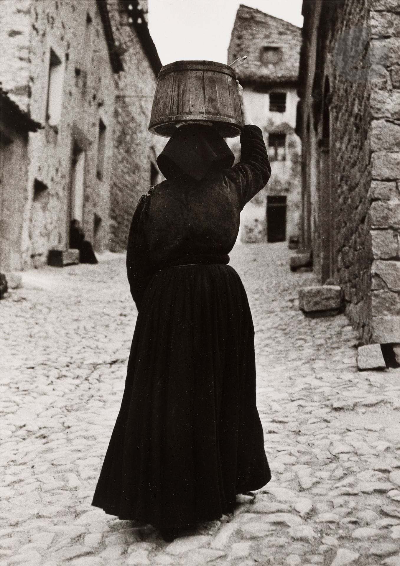Jean Dieuzaide (1921-2003)
Woman with barrel. Sardinia, 1956.
Silver print on Agfa paper (c. 1990). Stamp "Reportage photographique Yan", title and date in ink on verso. 
Image : 34.5 x 24.5 cm - Sheet : 40.5 x 30.5 cm