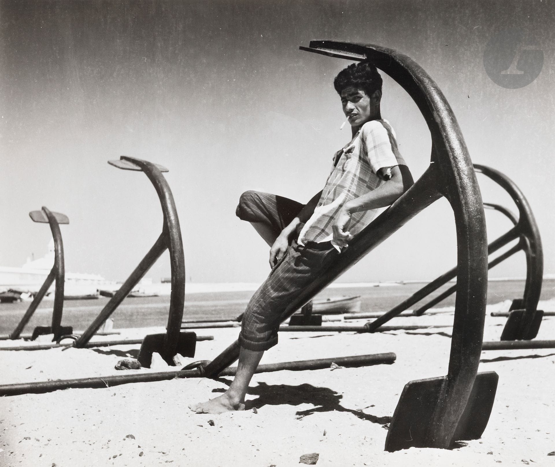 Jean Dieuzaide (1921-2003)
Young man and anchors. Portugal, 1954. 
Silver print (c. 1990). Stamp "Reportage photographique Yan", caption and date in pencil on verso. 
Image: 29.5 x 35 cm - Sheet: 30.4 x 40.2 cm