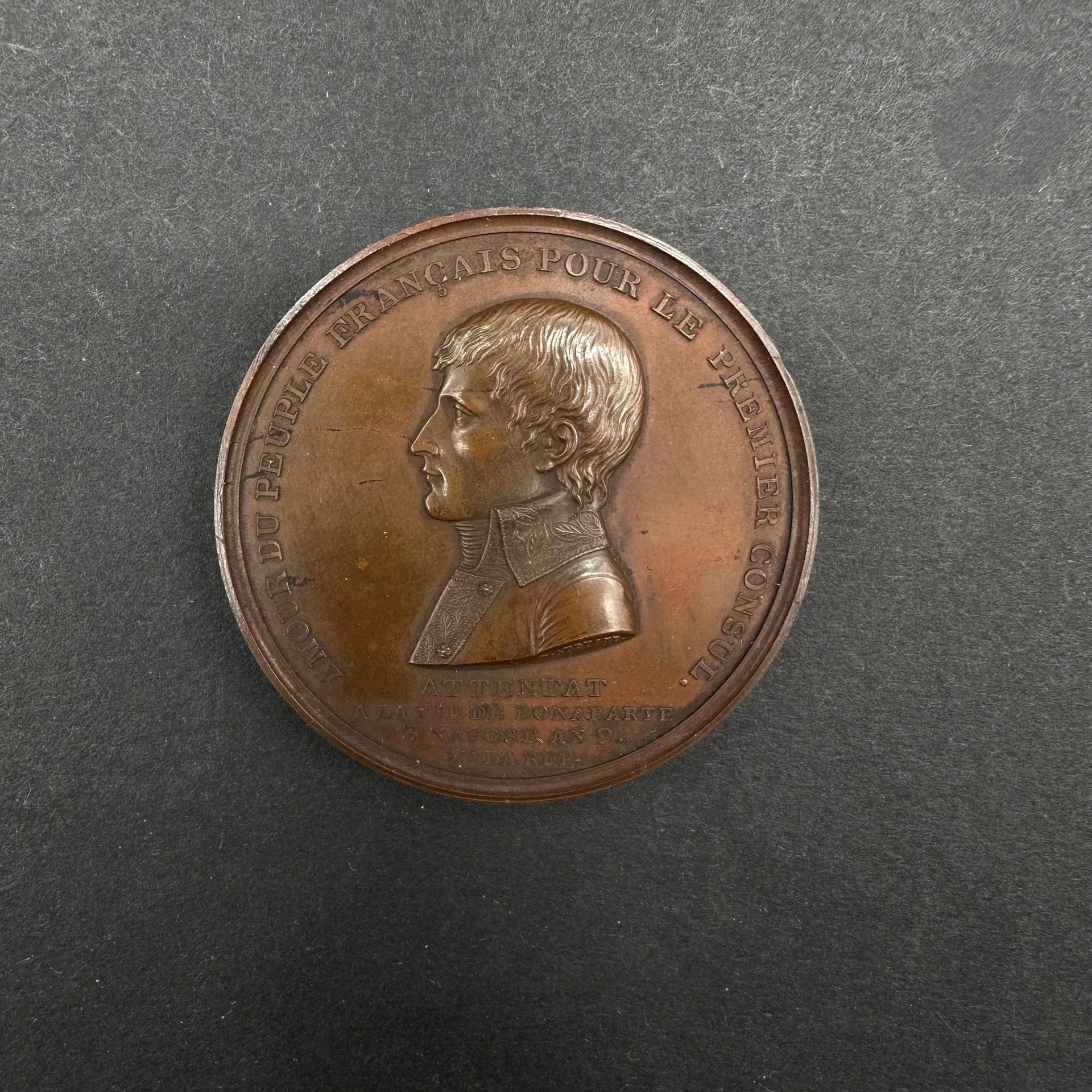 RUE SAINT-NICAISE BOMBING 

Bronze medal with patina by Auguste. 

Obverse: profile of the First Consul: 

"AMOUR DU PEUPLE FRANCAIS POUR LE PREMIER CONSUL / ATTENTAT / A LA VIE DE BONAPARTE / 3 NIVOSE AN 9. / DE LA REP".

Reverse: "LES CITOYENS / VOLENT EN FOULE VERSI. / AMIS / CE N'EST PAS A MOI / QU'IL FAUT VENIR: / QU'ON AILLE / QU'ON AILLE AU SECOURS / DES MALHEUREUX / QUE LA MACHINE INFERNALE / A PU PU FRAPPER".

49 mm

T.T.B. 

Reference : Br 76