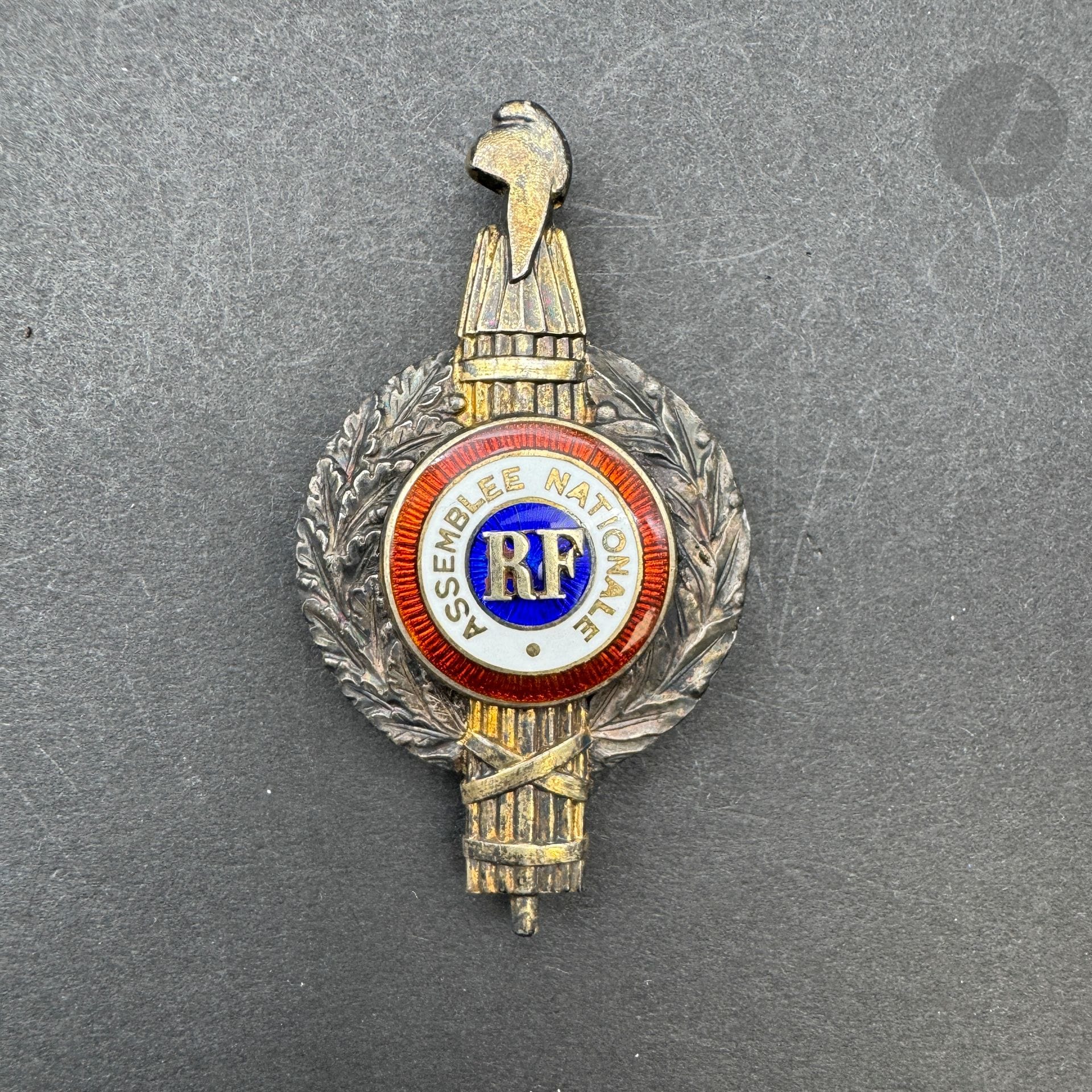 FRANCE 

Insigne de député modèle 1947 (IVe République). En argent, vermeil et émail. Poinçon tête de sanglier et d’orfèvre Chobillon. 

66 x 36 mm - Poids brut : 21 g

SUP.