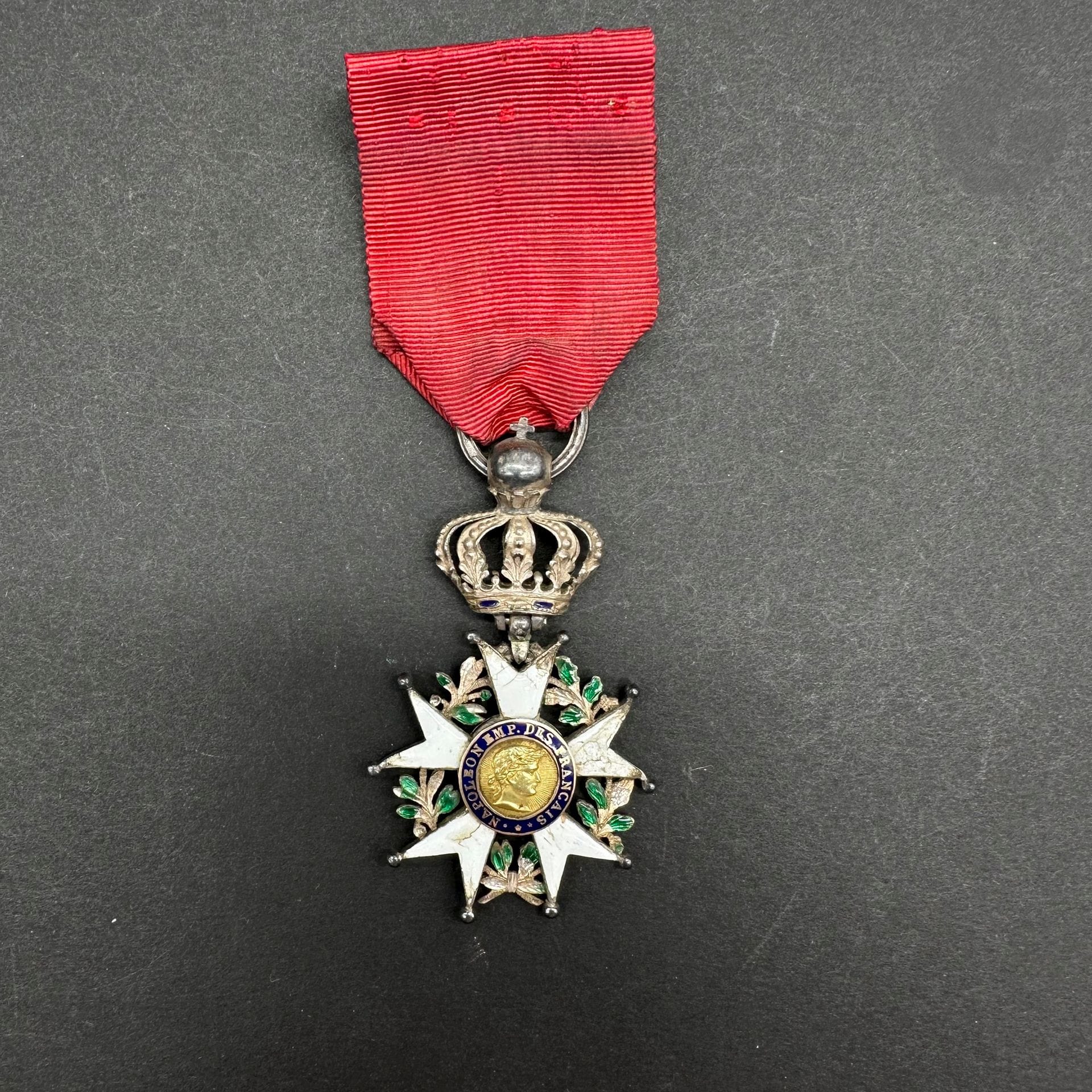 FRANCE

ORDRE DE LA LÉGION D’HONNEUR.

Étoile de chevalier modifiée 4e type, d’époque Ier Empire. Étoile en argent et émail (manque). Centre en or émaillé (éclats au revers). Montée à charnière, d’époque, avec une couronne du 4e type. Fort anneau cannelé poinçonné au faisceau de licteur (1809-1819). 

65 x 40 mm - Poids brut : 13,6 g

B. (Trois boules faussées)