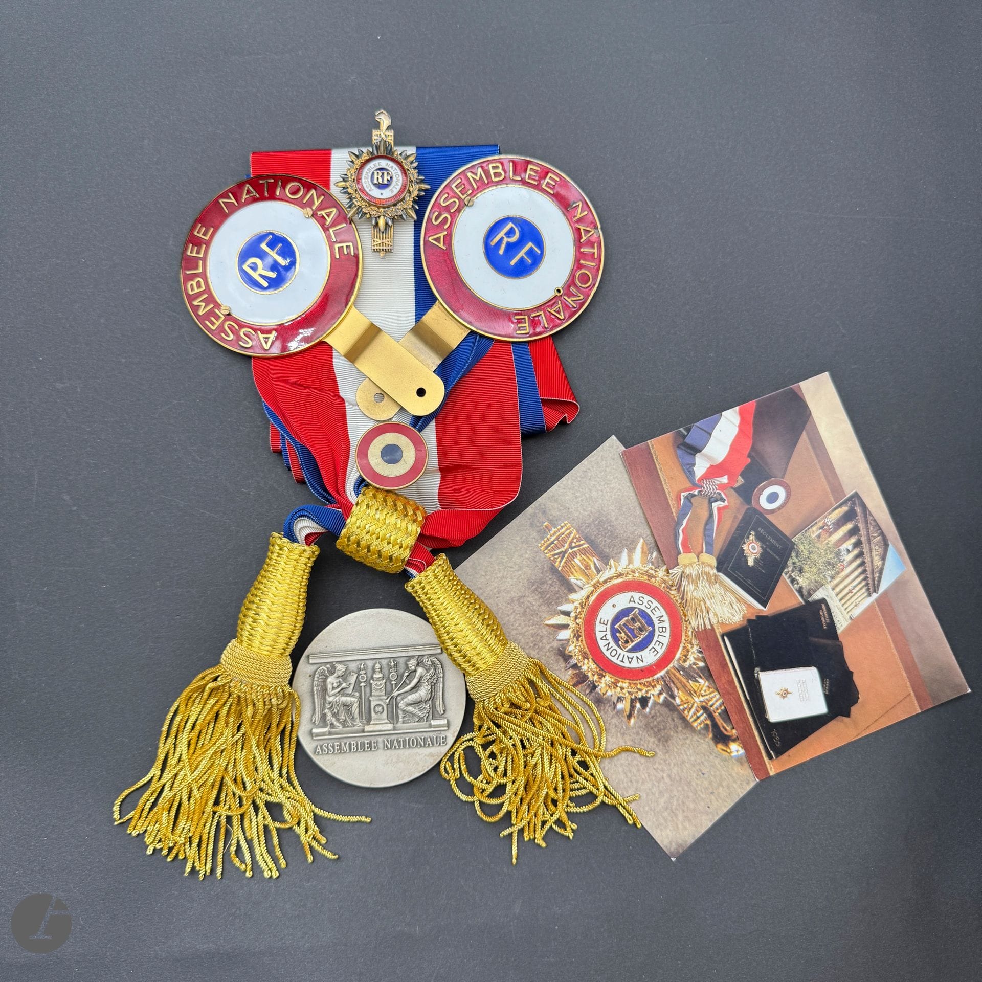 FRANCE 

Bel ensemble relatif aux députés de la Ve République : 

- Insigne portatif de député. 

En vermeil, argent et émail. Poinçon tête de sanglier et d’orfèvre Chobillon. 

66 x 44 mm - Poids brut : 25 g

- Écharpe de député, en moire tricolore à glands et franges en passementerie dorée. 

- Deux rondaches de fonction, en laiton doré et émaillé (éclats à une). 

- Médaille de l’Assemblée nationale en bronze argenté. 73 mm 

- Deux cartes postales. 

- Un insigne rondache tricolore.