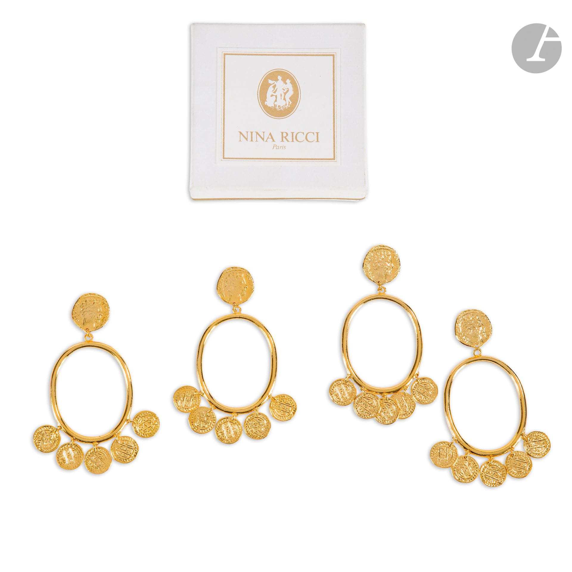 NINA RICCI
Deux paires de clips d'oreilles en métal doré créoles à petits pendentifs médailles. Signées. H : 8,5 cm. Dans leurs boîtes