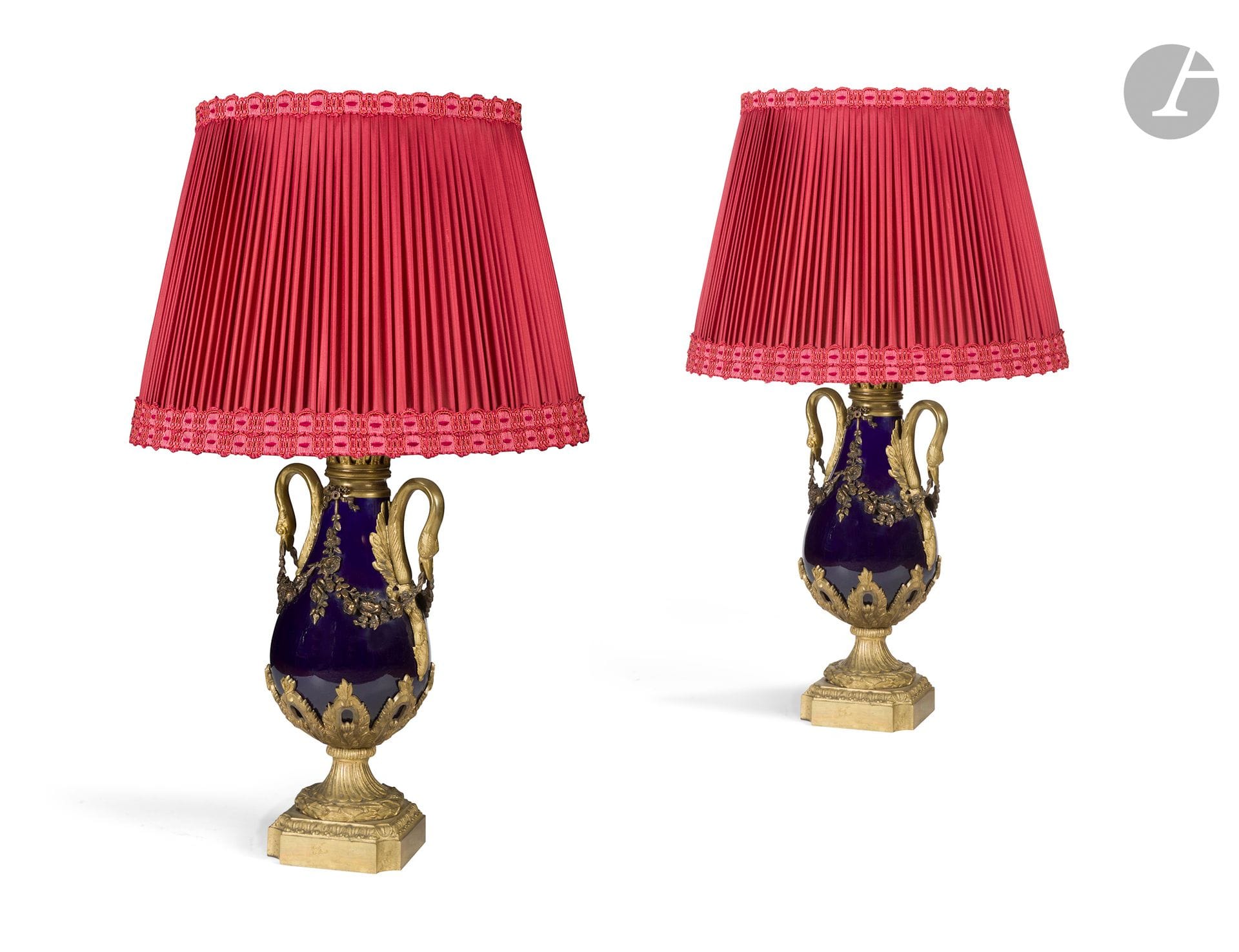 Paire de vases montés en lampe en porcelaine bleue, bronze doré et ciselé, les anses à col de cygne, guirlande de fleurs, feuillages, godrons, couronnes de laurier, socle quadrangulaire, à feuilles d'acanthe.
Style Louis XVI de la fin du XIXe siècle.
H. : 46 cm