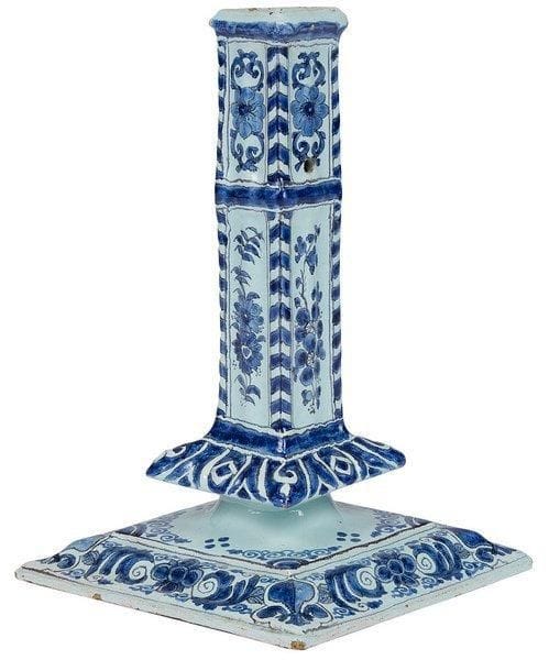 DELFT
Bougeoir à la financière à fût carré reposant sur une base carrée, à décor en camaïeu bleu de rinceaux fleuris et feuillagés et fleurs de lis. Fin du XVIIe siècle, début du XVIIIe siècle. H.: 23 cm