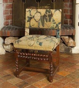 Chaise Louis XIII du XVIIe siècle. Elle repose sur des pieds avant tournés en torsades reliés par une double traverse avant torsadée également et en partie basse par une entretoise en H moulurée. Elle est couverte d'une ancienne tapisserie du XVIIe siècle. H.: 90 cm - L.: 53 cm - P.: 43 cm