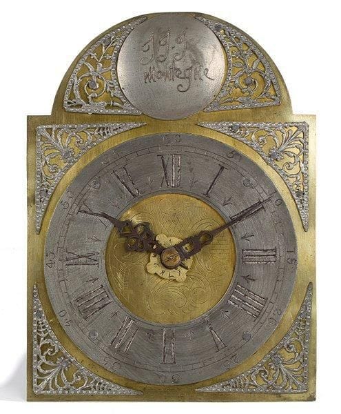 Horloge du Nord-Est à cadran en étain et écoinçons sur plaque gravée au centre. Le sommet en demi-lune porte un disque gravé J.J.J Montegne. Mouvement journalier à échappement à ancre à réveil-matin seul. Dispositif à pointes et crochet pour fixer l'ensemble sur le mur. Récemment restaurée. (Manque le balancier; avec ses poids et contrepoids issus de la restauration). XVIIIe siècle. H.: 32,5 cm - L.: 24 cm - P.: 14 cm