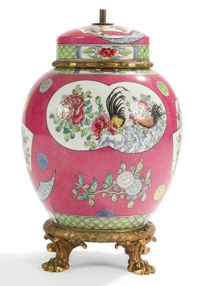 Potiche en porcelaine à décor de la famille rose à réserves de coqs combattant, pivoines, branches de pommier et semis de chrysanthèmes, monture en bronze ciselé et doré à cercle d'olives et tors de laurier reposant sur quatre pieds griffes feuillagés. Fin du XIXe siècle. Montée en lampe. H.: 36 cm