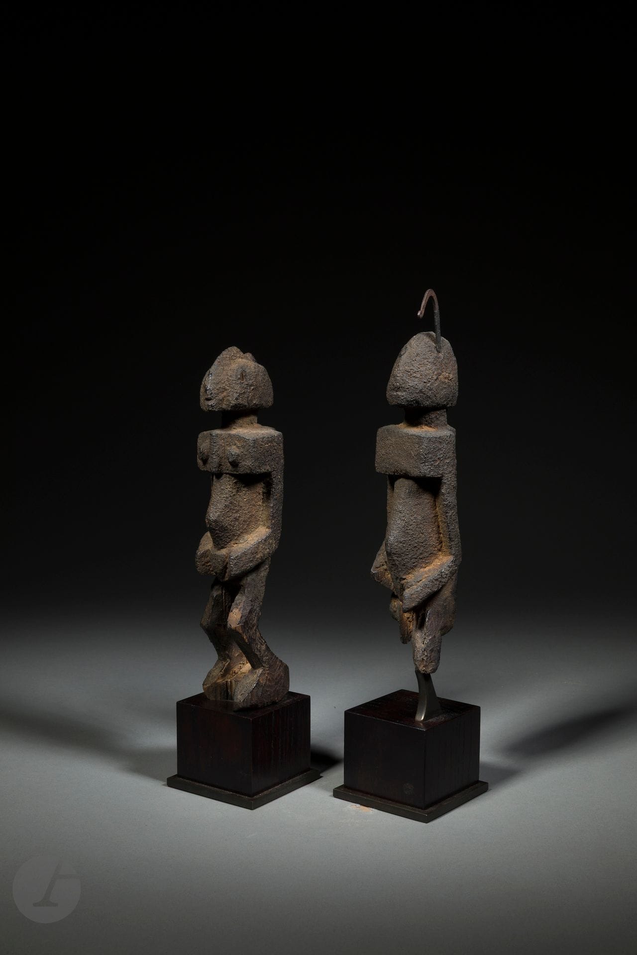 Un couple de belles et anciennes statuettes cultuelles, homme et femme, caractéristique des arts très stylisés de la statuaire Dogon, chacune ornéed’un petit fer forgé de forme recourbée (planté dans la tête).
Dogon, Mali
Bois, fer (l’un est ici cassé mais préservé à part), accidents anciens et érosion d’ancienneté (manque visible en partie basse), très belle et ancienne patine sacrificielle d’usage.
H. : 20 (22,5 avec le fer) et 21,5 cm

Provenance :
Yves Develon, Paris
Collection privée, Paris