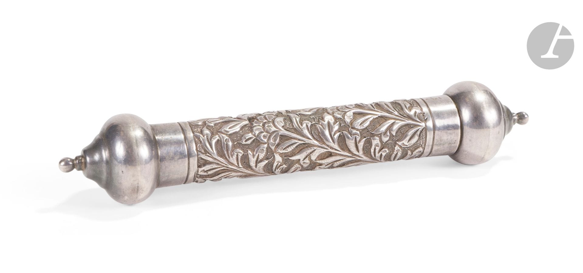 Rouleau généalogique « Shajarat Tayyiba » des shaykhs de la tariqa Naqshbandiyya, Inde, situé à la forteresse de Bhuj, signé et daté 1881
Rouleau de papier cartonné calligraphié d’un texte de 40 lignes en arabe cursif à l’encre noire, encadré de deux panneaux peints d’un décor floral à la gouache et à l’or déployé autour du titre « Shajarat Tayyiba » (« Arbre bon, pur ») en tête du rouleau et d’un médaillon fleuronné en fin de rouleau, qui indique la copie par Najm al-Hassan Naqshbandi à la forteresse de Bhuj au mois de Safar de 1299 H / décembre 1881. Le texte principal est une série d’invocations religieuses où sont nommées différentes personnalités religieuses de l’islam comme le Prophète Muhammad, Abu Bakr Siddiq, Ja’far al-Sadiq, Abu’l Hassan al-Kharaqani, Yusuf Hamdani, etc… Dans son étui cylindrique en argent, aux extrémités bulbeuses et à décor floral moulé et ciselé. Au dos, grande composition florale peinte à la gouache et à l’or dans la continuité des panneaux enluminés de la face. 
70 x 12 cm, L. étui : 20 cm ; poids brut étui : 135 g
Usure, quelques sauts d’encre et de polychromie, petits chocs sur l’étui.

La Tariqa Naqshbandiyya est une confrérie soufie fondée au XIIe siècle qui tire son nom de l’ouzbek Khwaja Shâh Bahâ’uddîn Naqshband (1317-89) considéré par ses adeptes comme leur maître. « Shajarat Tayyiba », que titre ce rouleau, signifie littéralement « Le Bon Arbre ». Il est mentionné dans le Coran, Sourate Ibrahim, versets 24-25. Dans le soufisme, il s’agit d’une chaîne initiatique (silsila) comparable à un arbre généalogique qui lierait entre eux des disciples à leur maître, remontant ainsi jusqu’au Prophète Muhammad ici cité dans la première des quarante invocations. 
La forteresse de Bhuj mentionnée dans le colophon se réfère peut-être à une ville éponyme du Gujarat.